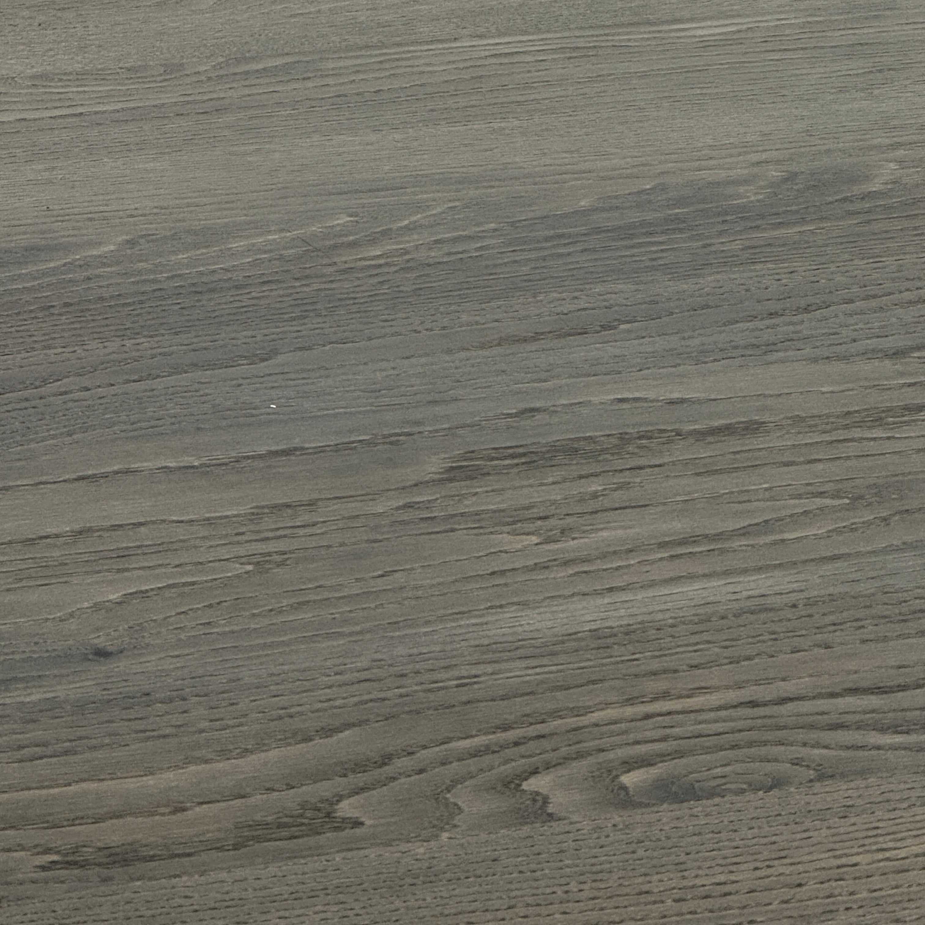 The BDDW Solid Oak dining table by BDDW features a simple, modern rectangular design and is set against a plain white wall on a polished concrete floor.