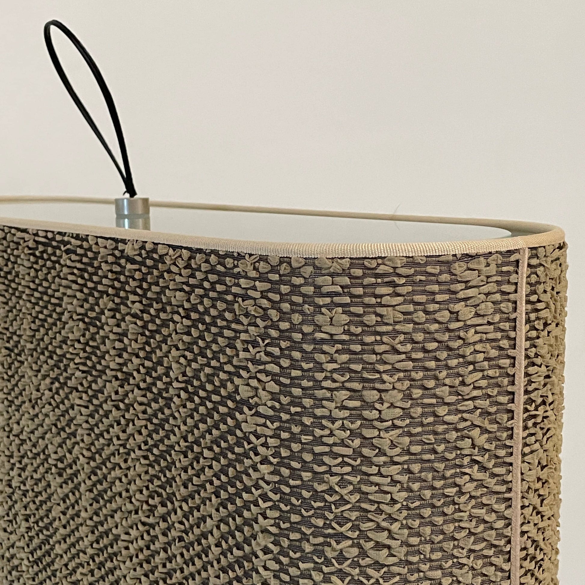 Two-tiered, textured fabric lampshade with a loop finial on a white background for the Luminara Dabliu Table Light by Luminara.