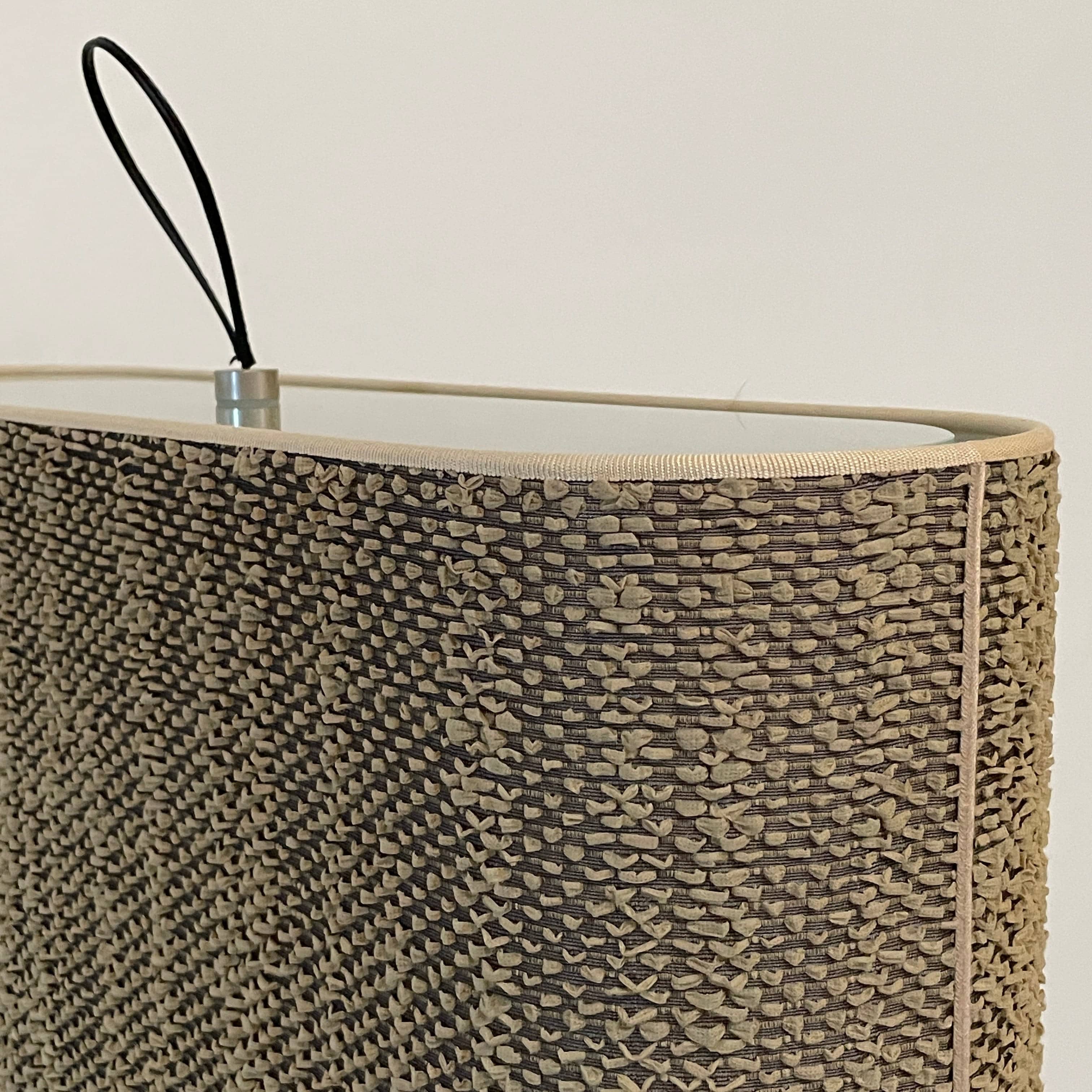 Two-tiered, textured fabric lampshade with a loop finial on a white background for the Luminara Dabliu Table Light by Luminara.