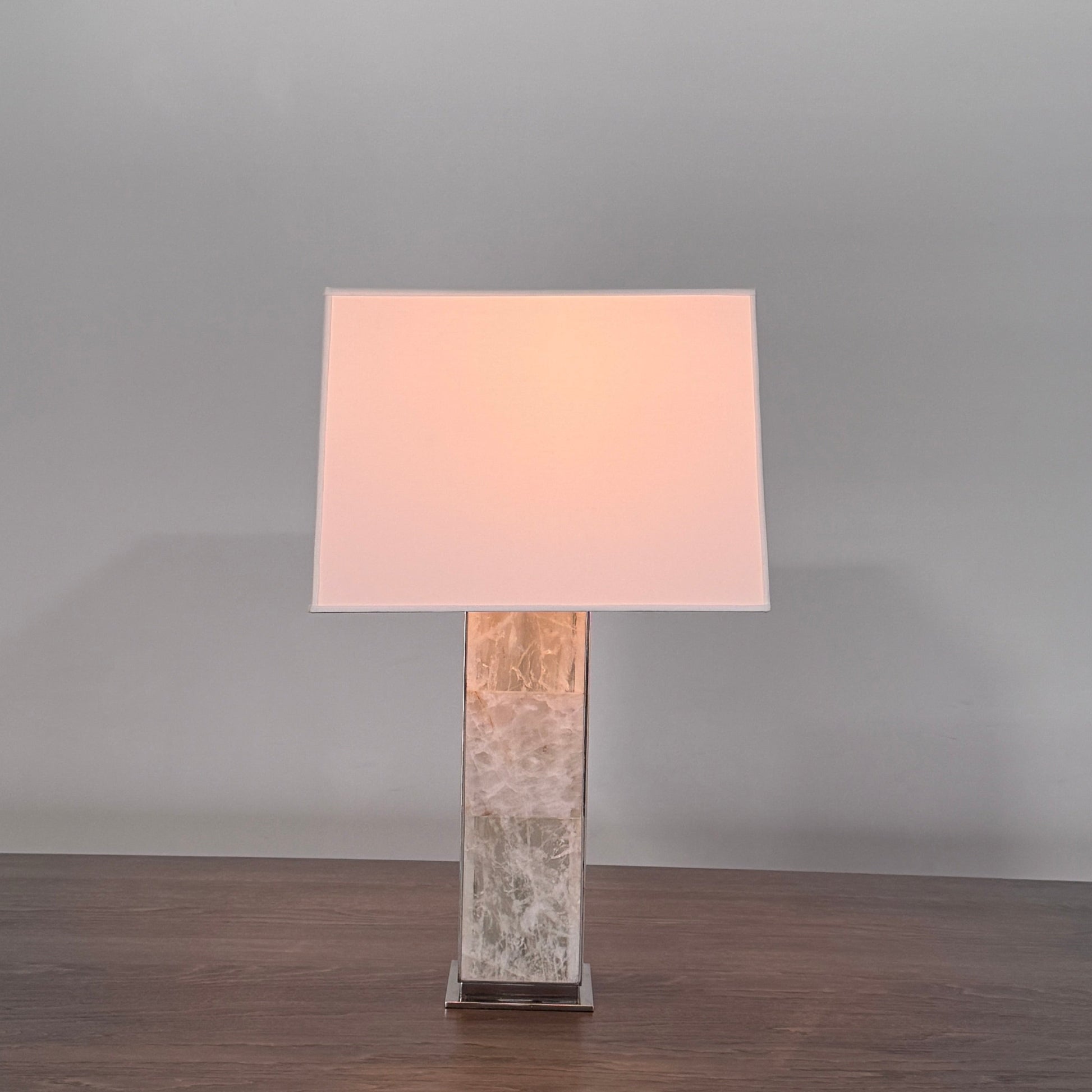 The Visual Comfort Ellis Quartz Table Lamp by Ralph Lauren features a rectangular white shade and a translucent, textured quartz base, shown against a plain white background.