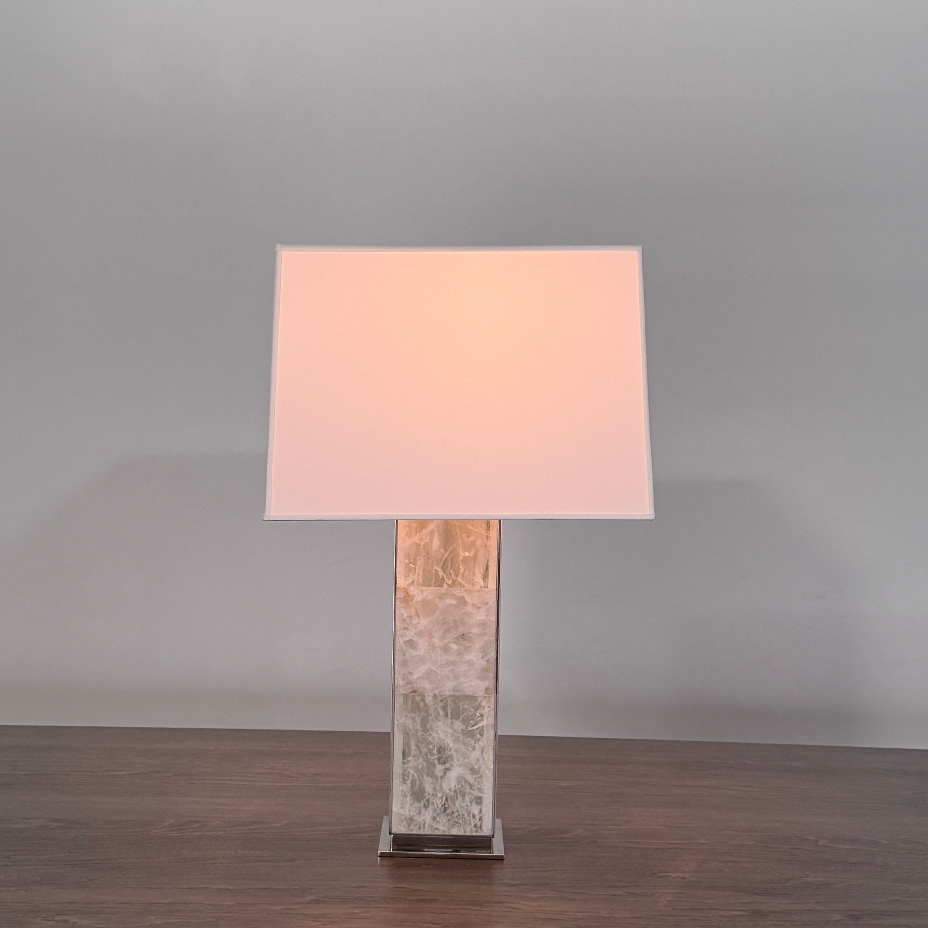 The Visual Comfort Ellis Quartz Table Lamp by Ralph Lauren features a rectangular white shade and a translucent, textured quartz base, shown against a plain white background.