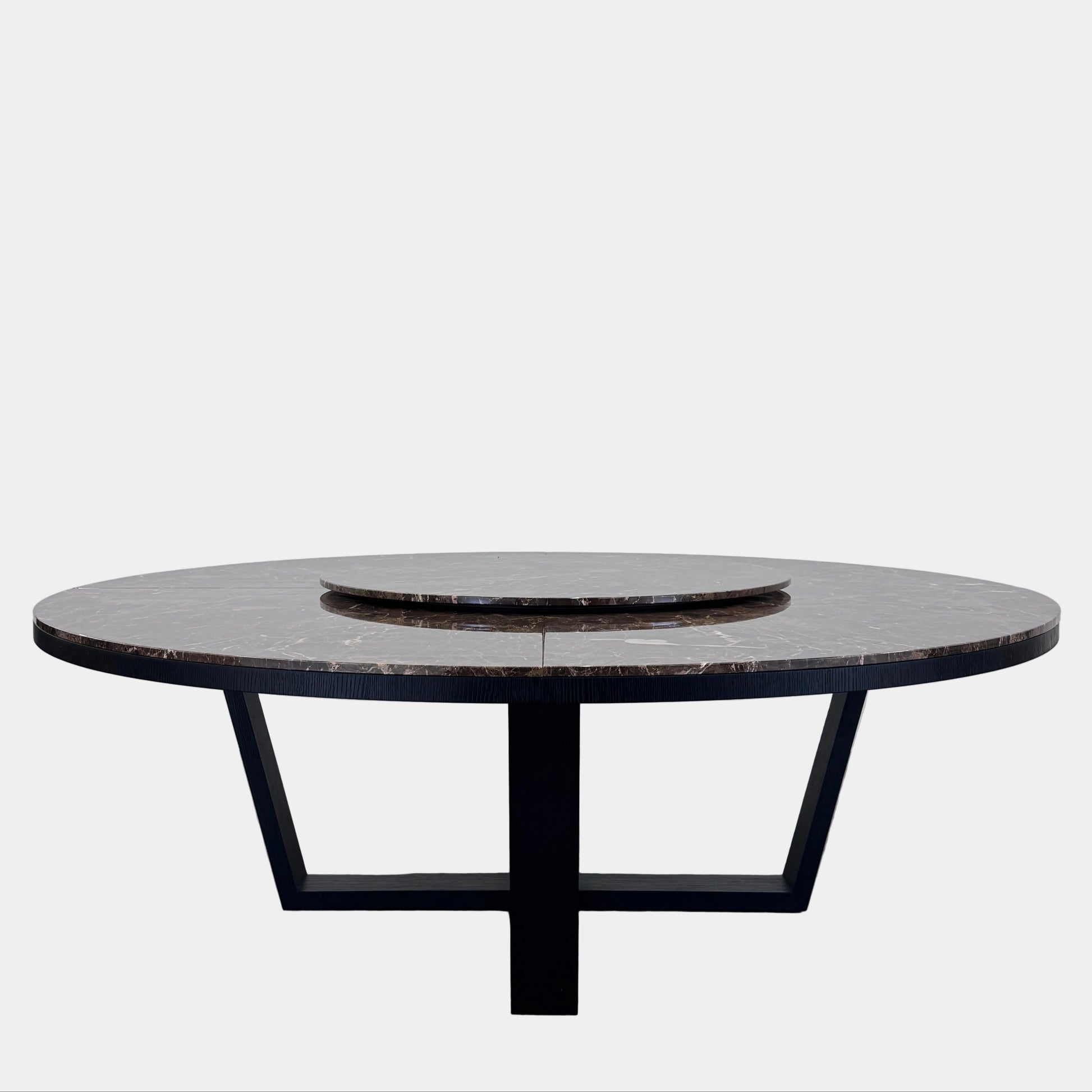 The Maxalto Xilos Dining Table with Rotating Tray by Maxalto features a round, dark finish and a black geometric base, shown here against a plain light background.