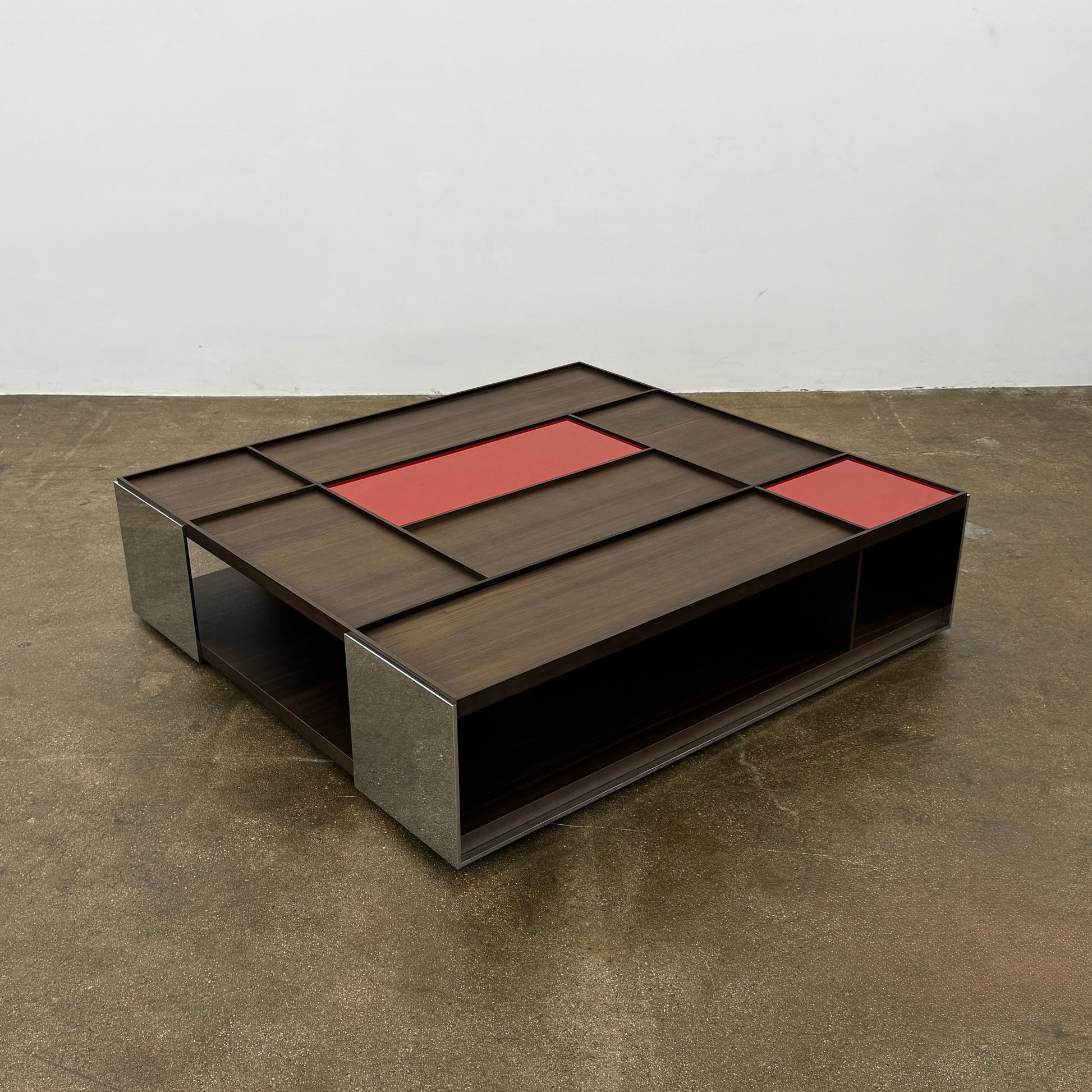 A modern square coffee table by B&B Italia, the Surface Coffee Table features wood, concrete-like panels, and two red rectangular accents—ideal for admirers of geometric designer furniture.