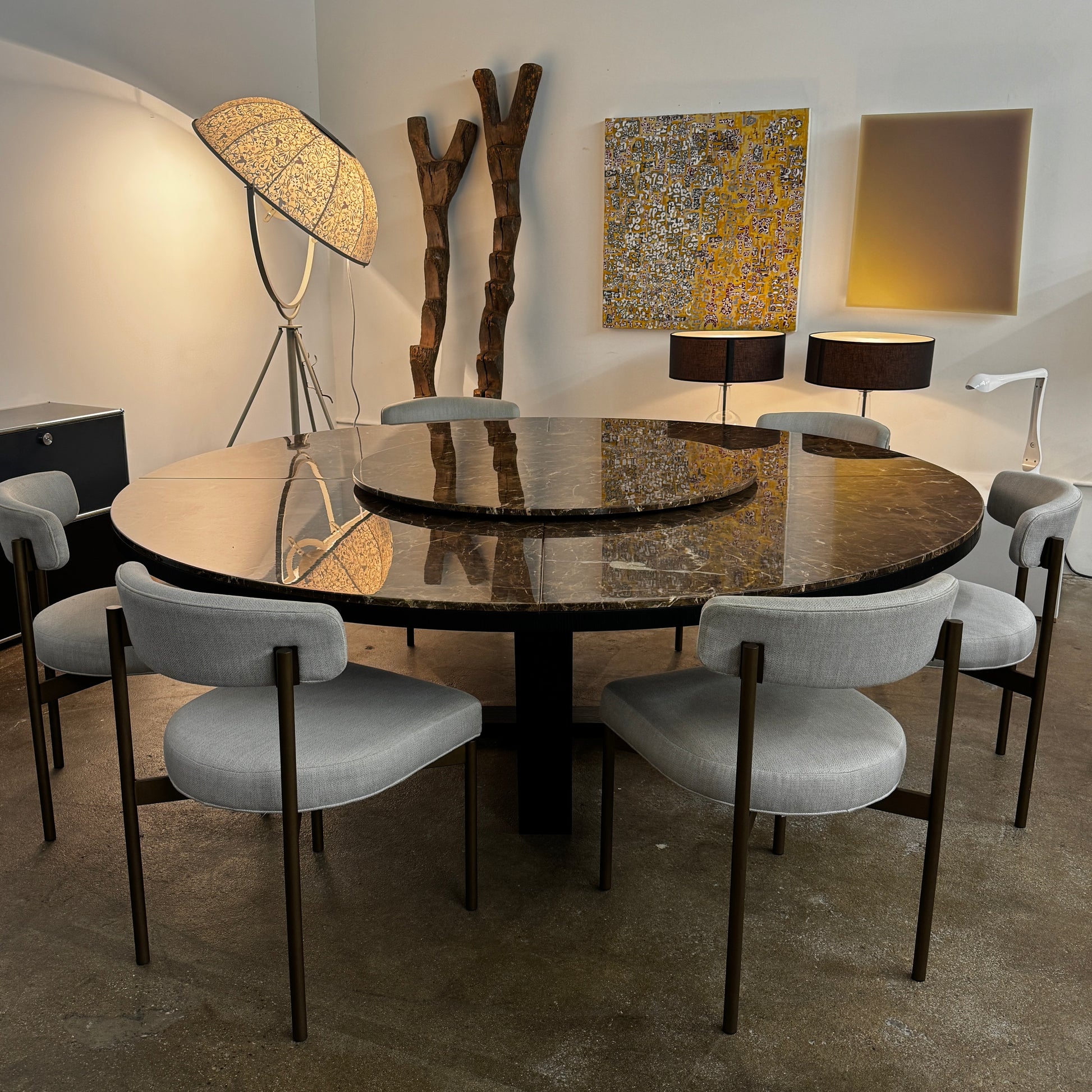 The Maxalto Xilos Dining Table with Rotating Tray by Maxalto features a round, dark finish and a black geometric base, shown here against a plain light background.