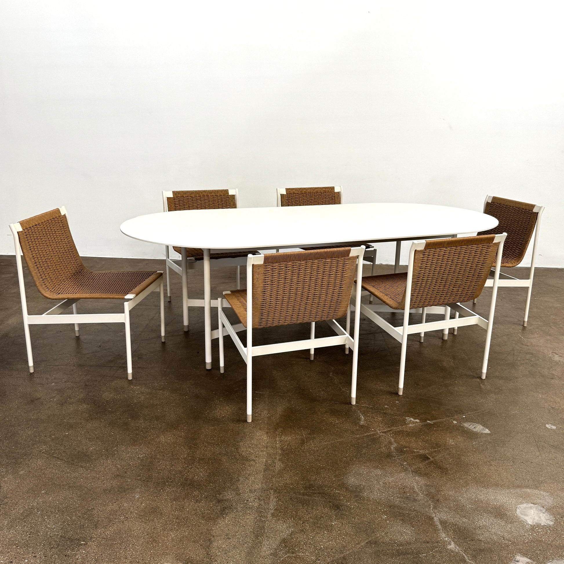 Nine MillerKnoll Sommer Outdoor Dining Chairs for DWR, sold in sets of 2, with metal frames and weatherproof wicker seats and backs, are arranged in three rows against a plain white background.
