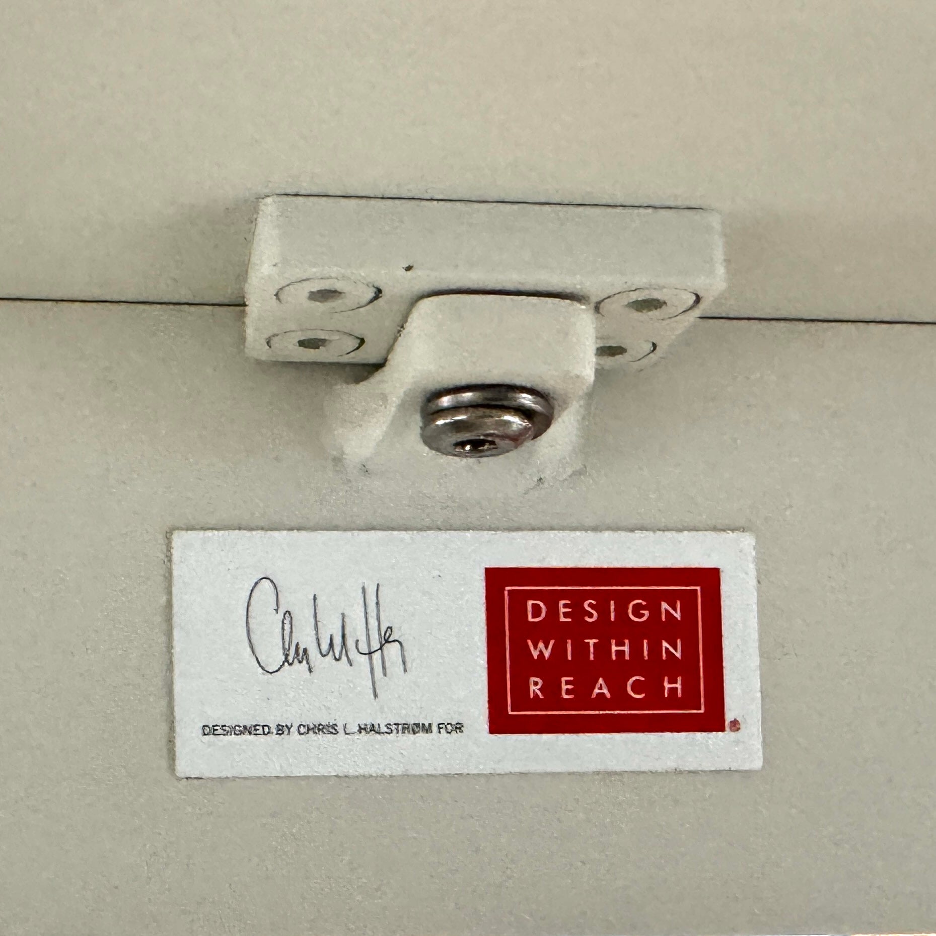 The MillerKnoll Outdoor Sommer Oval Dining Table for DWR, paired with six brown wicker chairs on a polished concrete floor against a white wall, is ideal for fans of modern patio furniture and minimalist design.