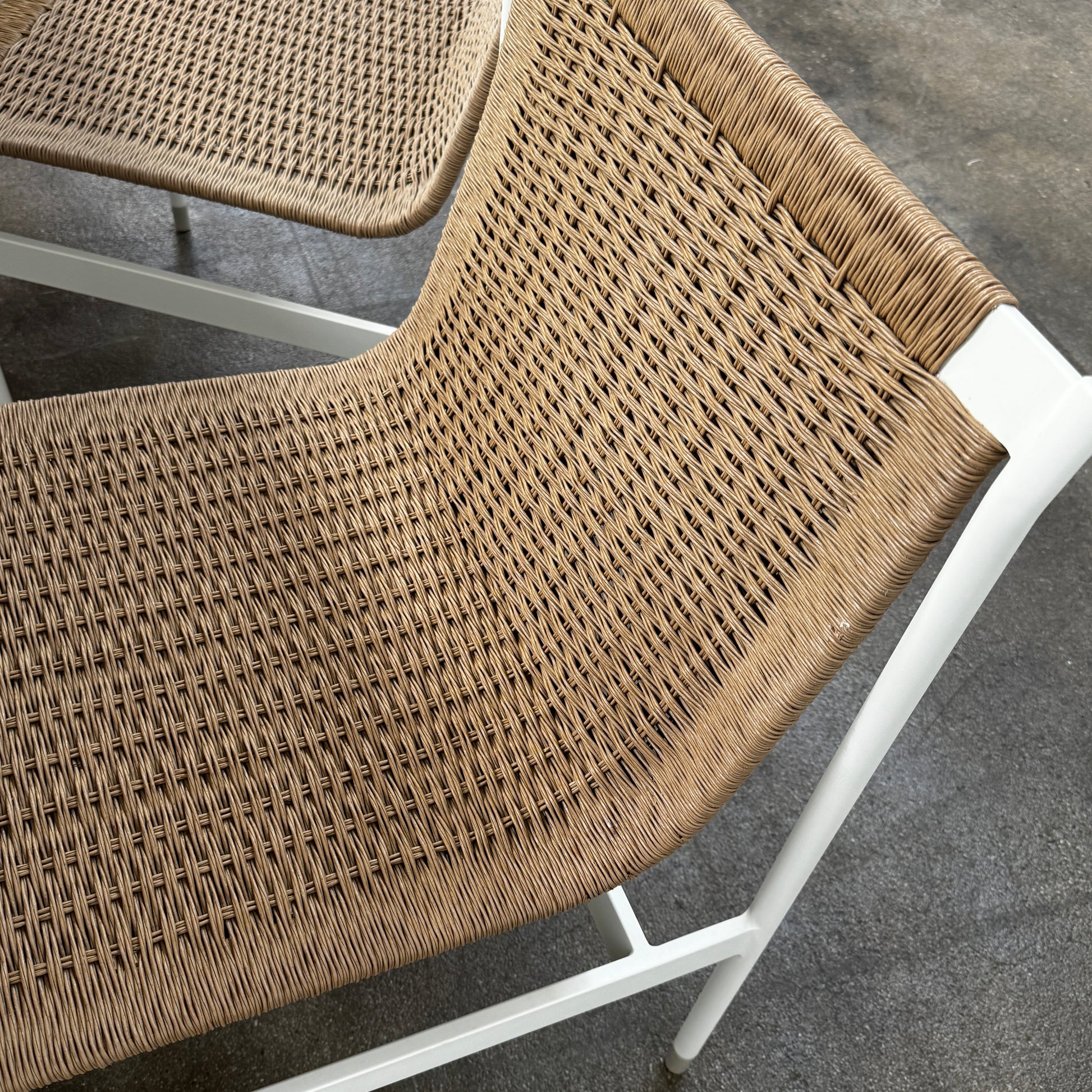 Nine MillerKnoll Sommer Outdoor Dining Chairs for DWR, sold in sets of 2, with metal frames and weatherproof wicker seats and backs, are arranged in three rows against a plain white background.