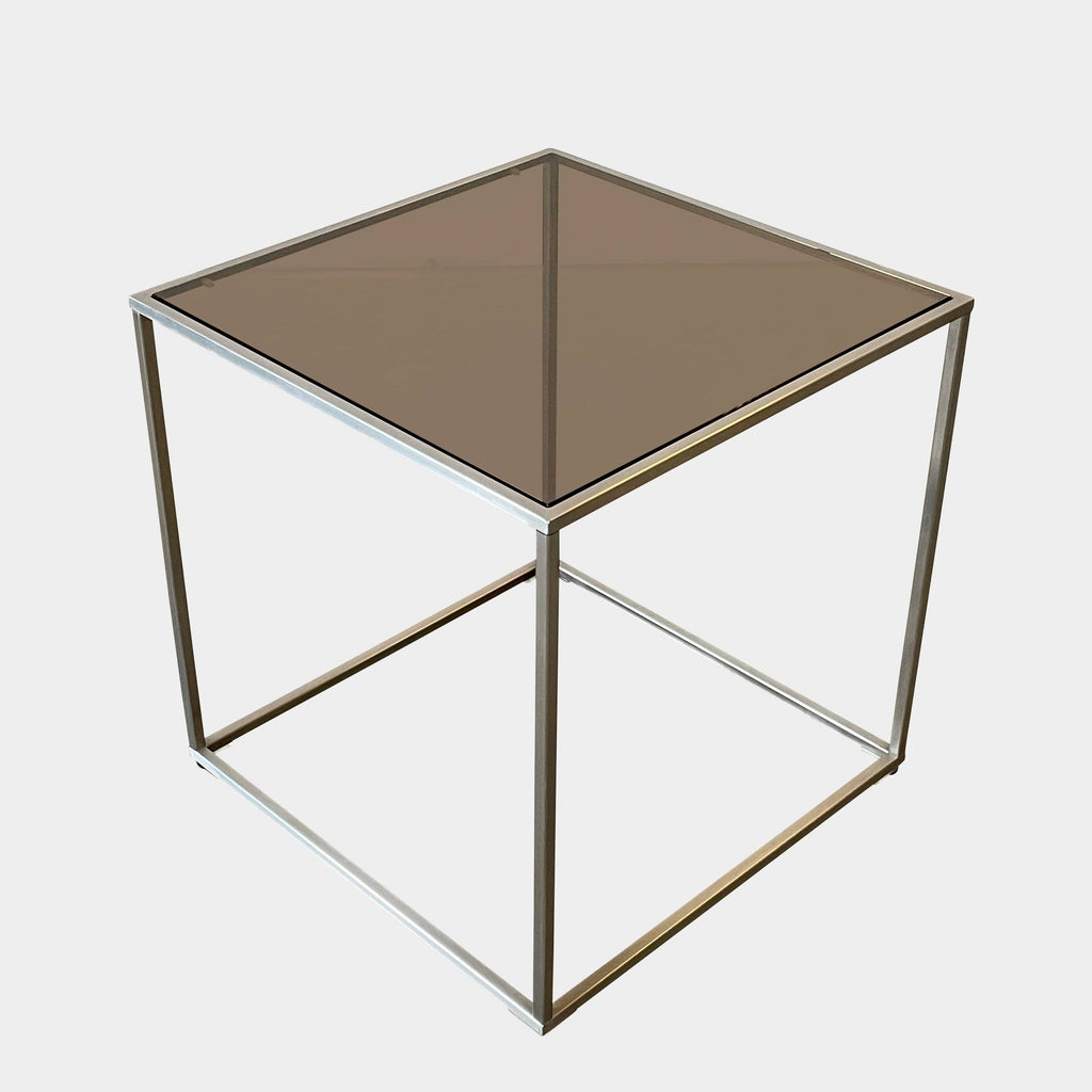 The Living Divani Ile Side Table is a sleek and modern addition to any contemporary environment. Made from square metal, this table features a glass top that adds an elegant touch to any space. Perfect for