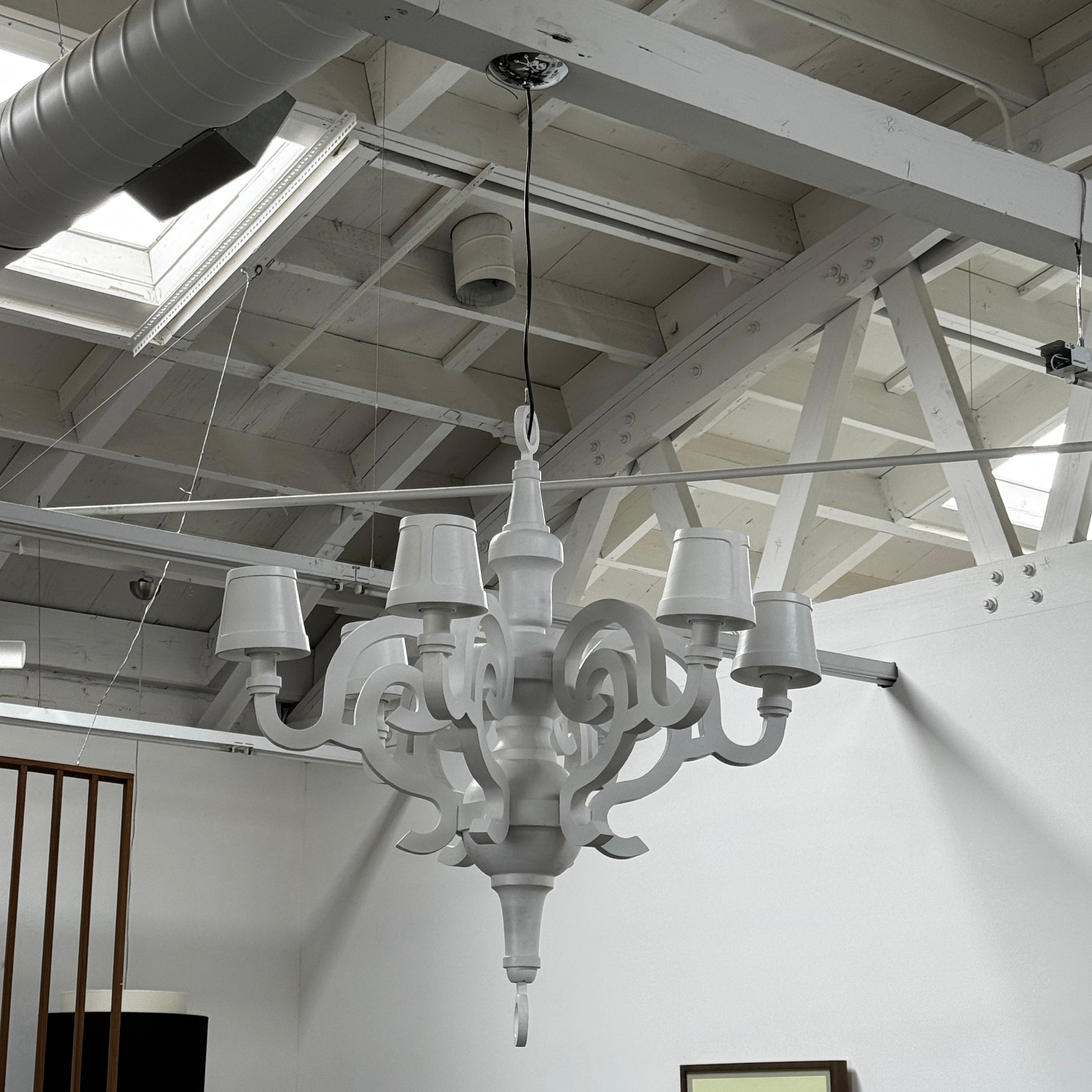 A white Moooi Paper Chandelier by Modern Resale with six arms and lampshades hangs from the ceiling on a black cord, serving as a striking 6 Light Chandelier centerpiece against a plain background.