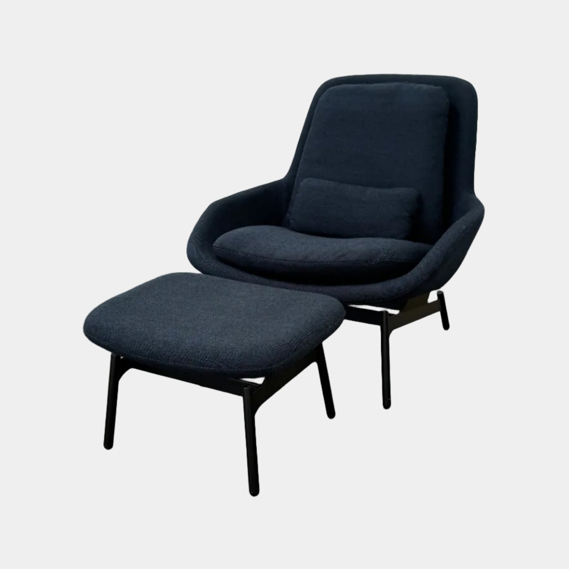 A Bludot Field Chair & Ottoman by Blu Dot, in modern black, is placed on a brown concrete floor with a white background.