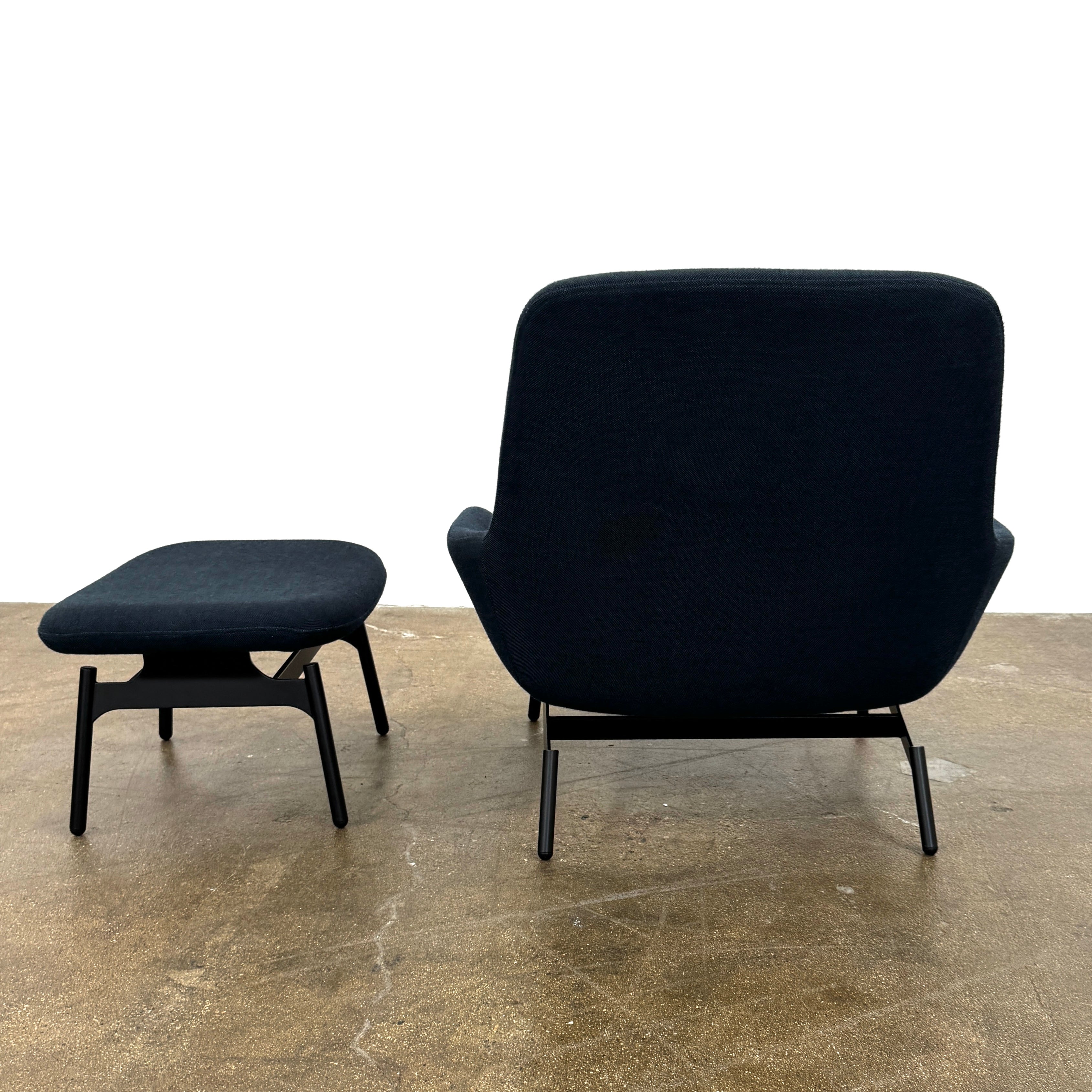 A Bludot Field Chair & Ottoman by Blu Dot, in modern black, is placed on a brown concrete floor with a white background.