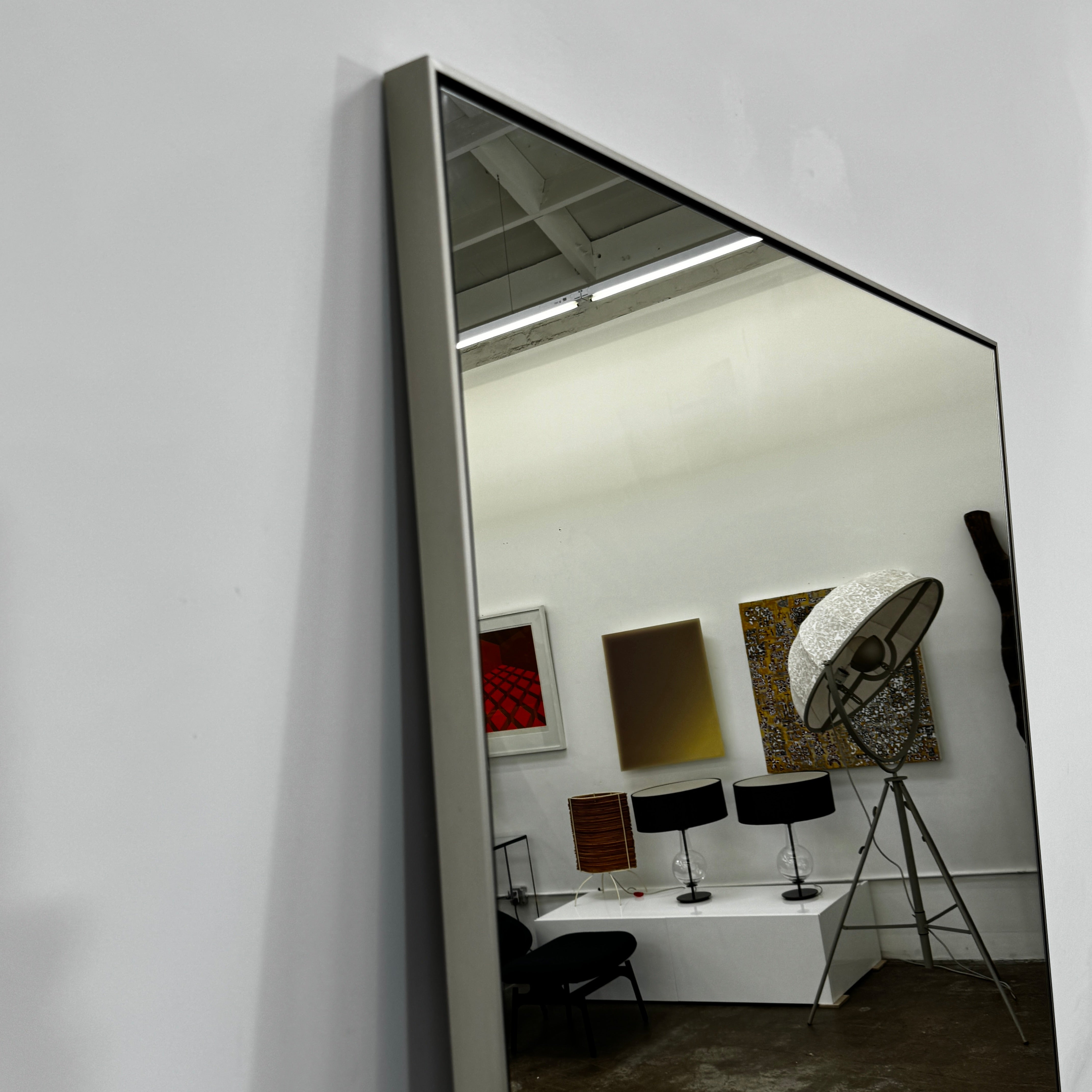 The DWR Mondrian Wall Hanging Mirror (44" x 80") by DWR features a sleek, minimalist rectangular design with a thin, dark frame and stands upright against a plain white backdrop for a modern look.
