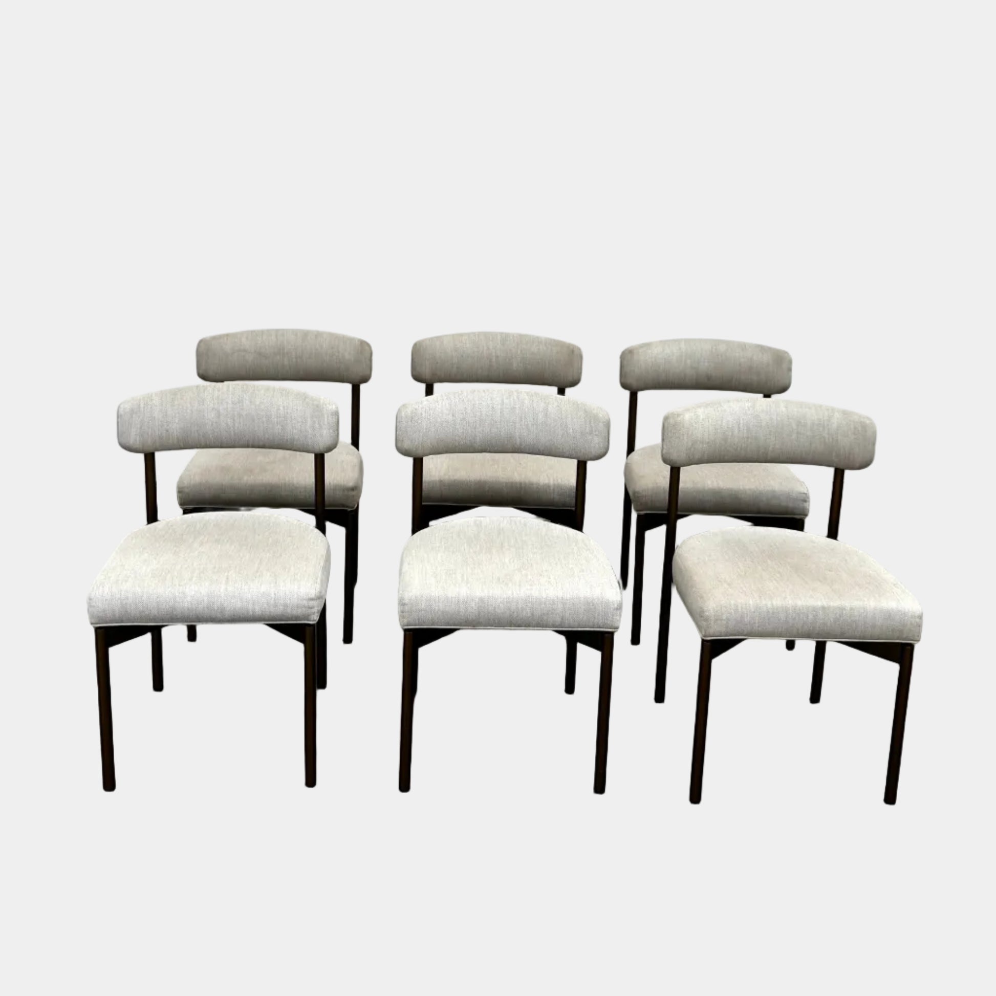 Set of six Mitchell Gold + Bob Williams Remy dining chairs with light beige upholstered seats and backs, dark wooden legs and frames, arranged in two rows against a plain light background.