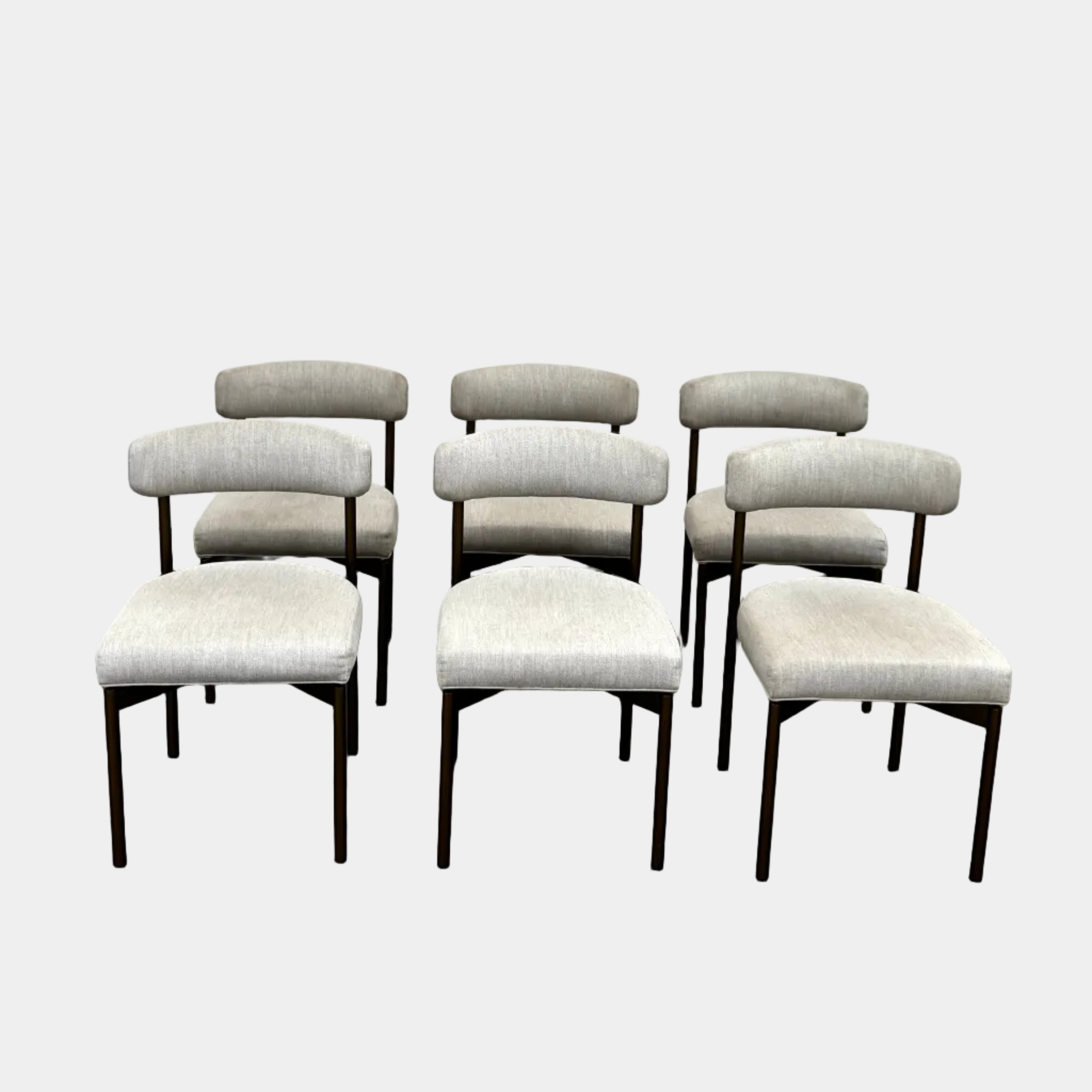 Set of six Mitchell Gold + Bob Williams Remy dining chairs with light beige upholstered seats and backs, dark wooden legs and frames, arranged in two rows against a plain light background.