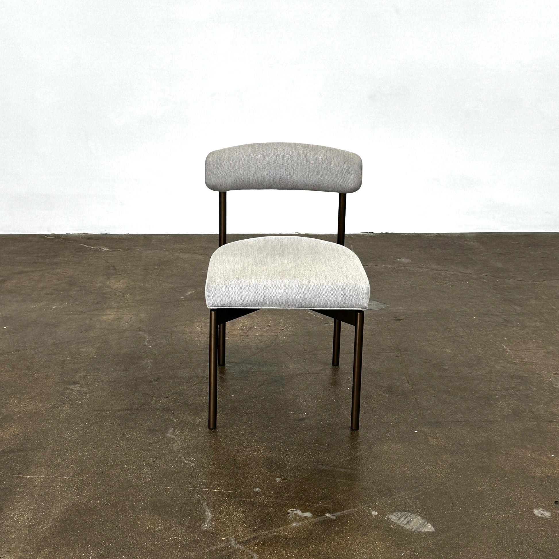 Set of six Mitchell Gold + Bob Williams Remy dining chairs with light beige upholstered seats and backs, dark wooden legs and frames, arranged in two rows against a plain light background.