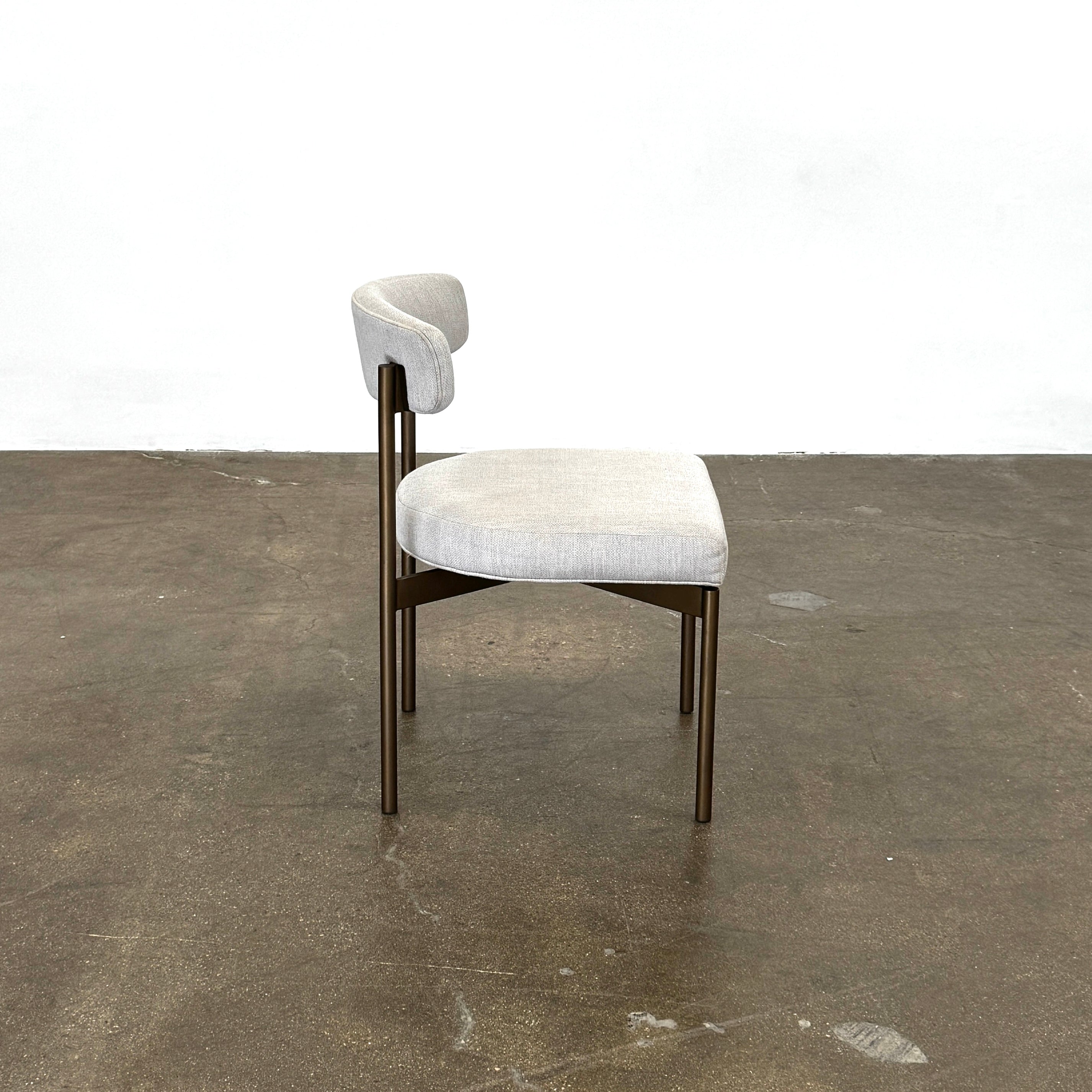 Set of six Mitchell Gold + Bob Williams Remy dining chairs with light beige upholstered seats and backs, dark wooden legs and frames, arranged in two rows against a plain light background.