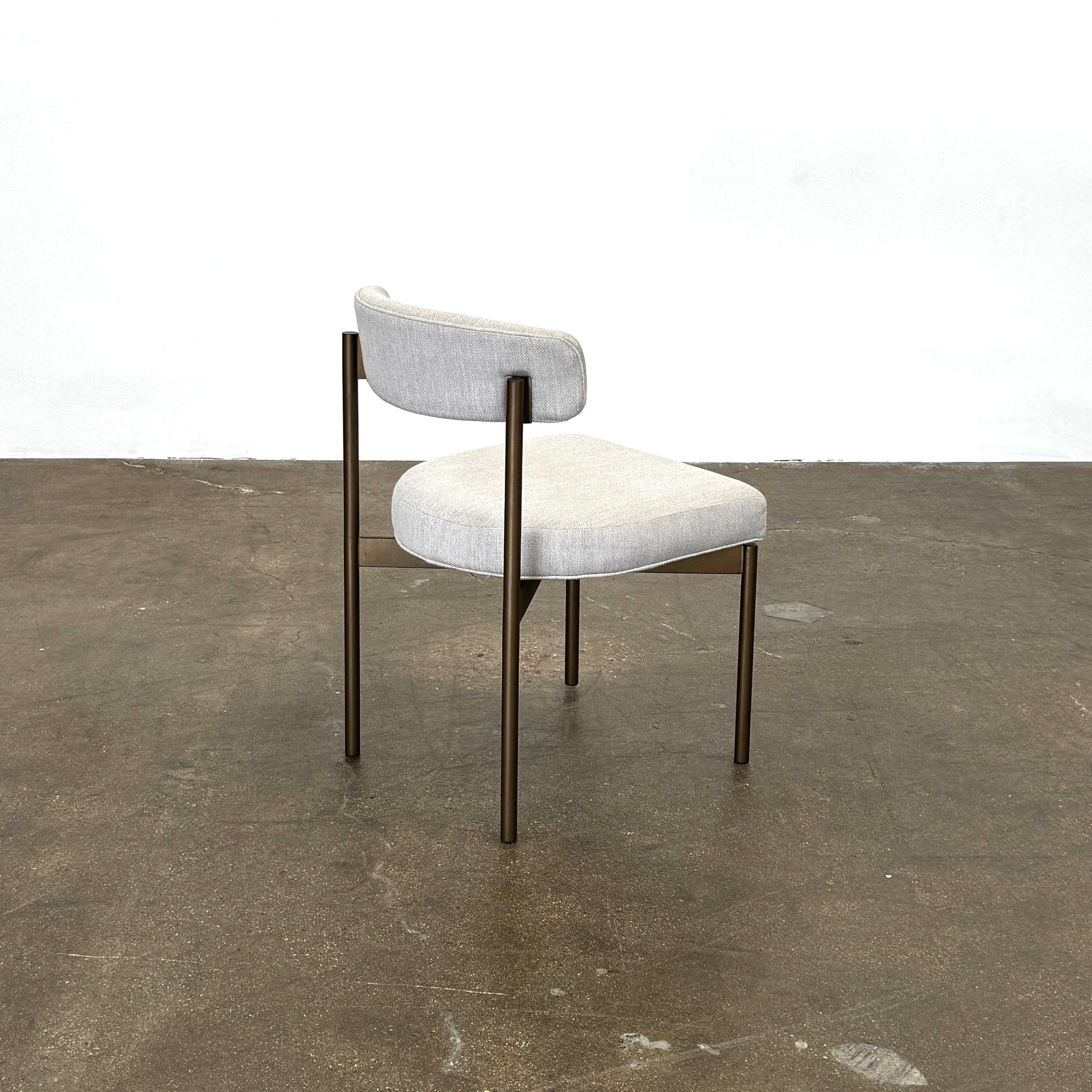 Set of six Mitchell Gold + Bob Williams Remy dining chairs with light beige upholstered seats and backs, dark wooden legs and frames, arranged in two rows against a plain light background.