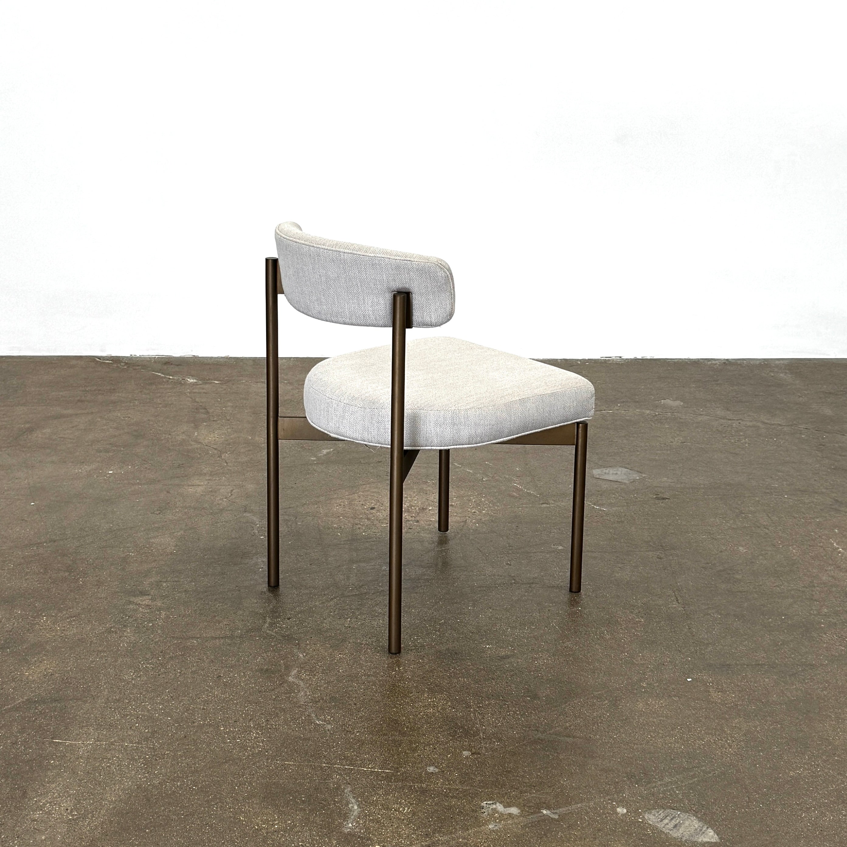 Set of six Mitchell Gold + Bob Williams Remy dining chairs with light beige upholstered seats and backs, dark wooden legs and frames, arranged in two rows against a plain light background.