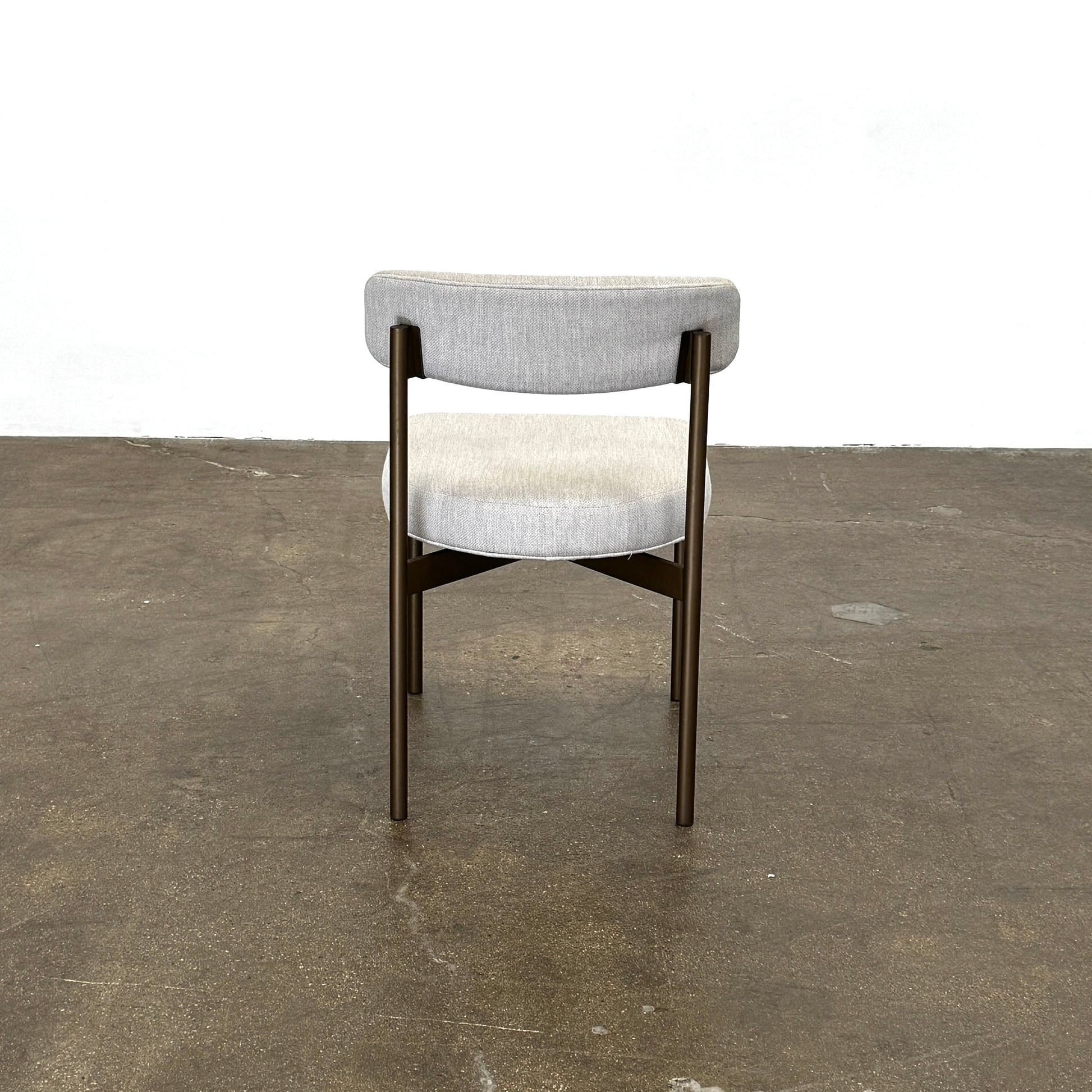 Set of six Mitchell Gold + Bob Williams Remy dining chairs with light beige upholstered seats and backs, dark wooden legs and frames, arranged in two rows against a plain light background.