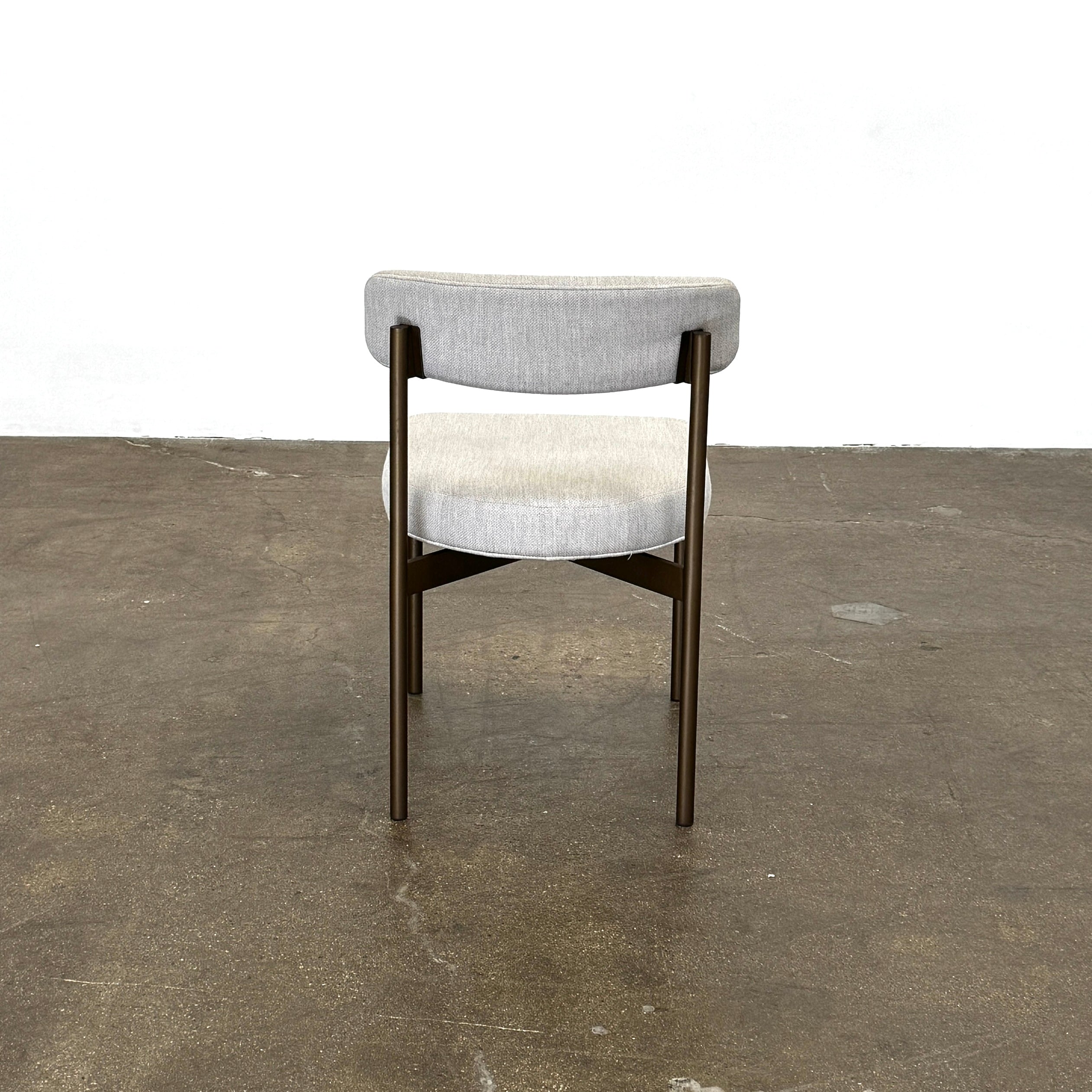 Set of six Mitchell Gold + Bob Williams Remy dining chairs with light beige upholstered seats and backs, dark wooden legs and frames, arranged in two rows against a plain light background.