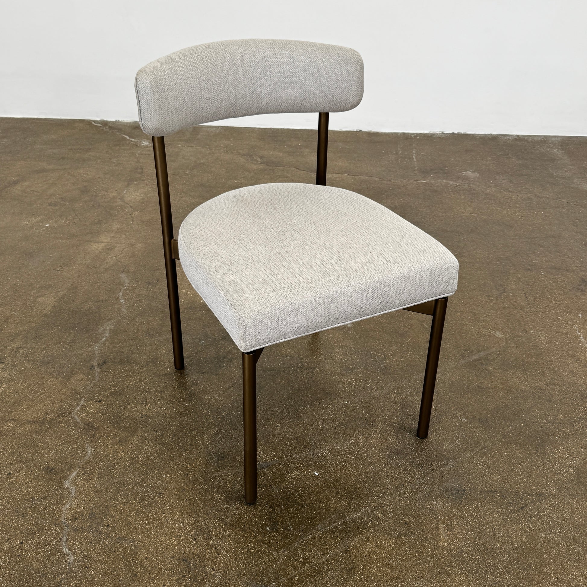 Set of six Mitchell Gold + Bob Williams Remy dining chairs with light beige upholstered seats and backs, dark wooden legs and frames, arranged in two rows against a plain light background.