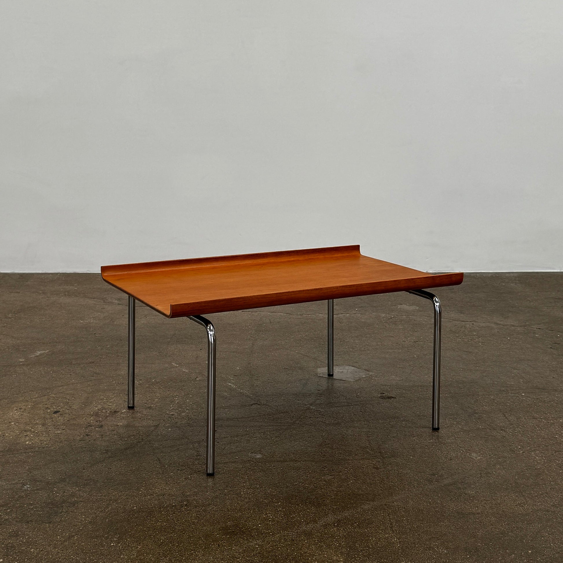 The Cappellini Side Table by Cappellini features stained beechwood, a raised back edge, and four chromed steel legs, shown against a plain white background.