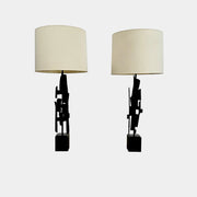 A pair of Vintage Richard Barr Iron Brutalist table lamps for Laurel Lamp Co., featuring abstract black metal bases and cylindrical white shades, set against a plain white background.