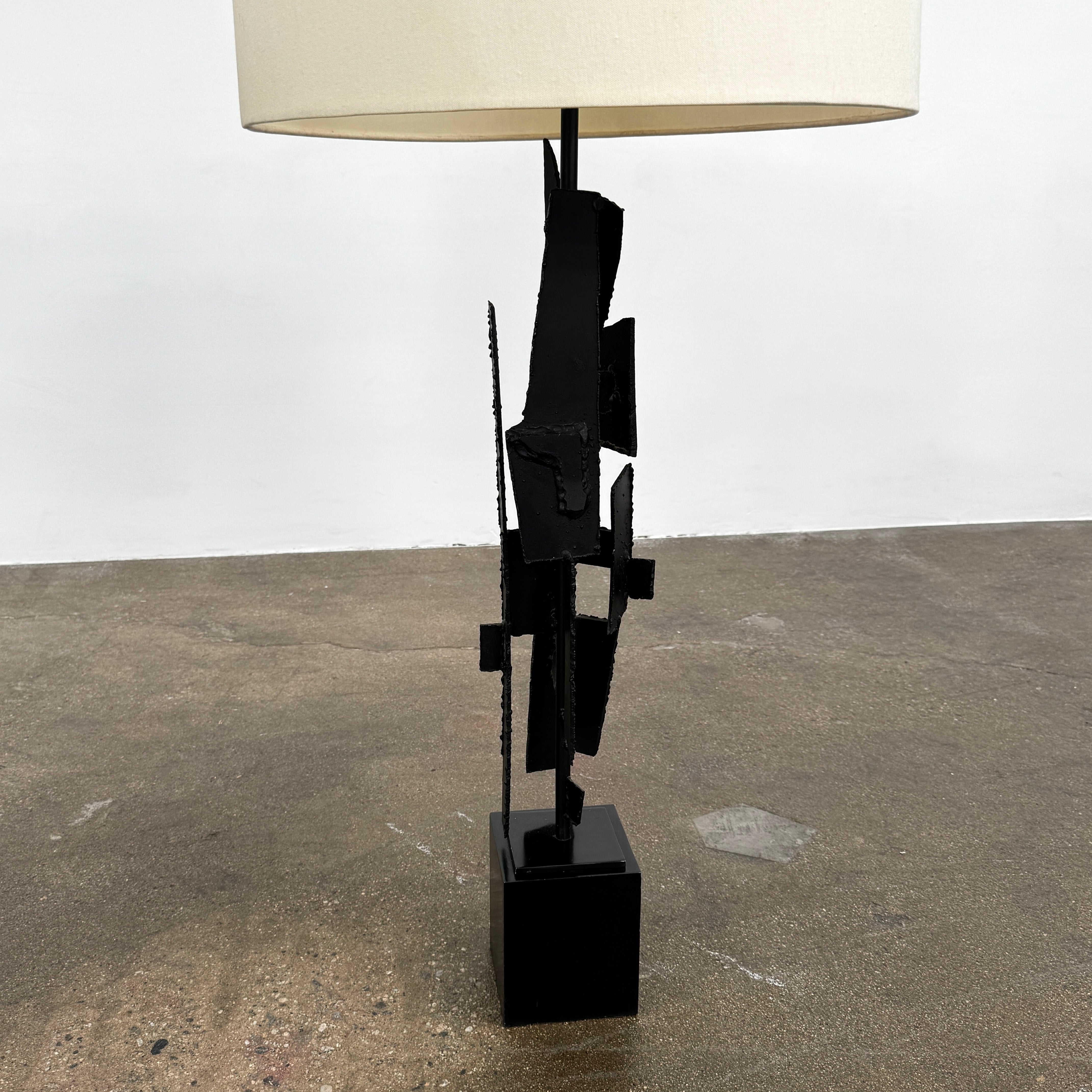 A pair of Vintage Richard Barr Iron Brutalist table lamps for Laurel Lamp Co., featuring abstract black metal bases and cylindrical white shades, set against a plain white background.