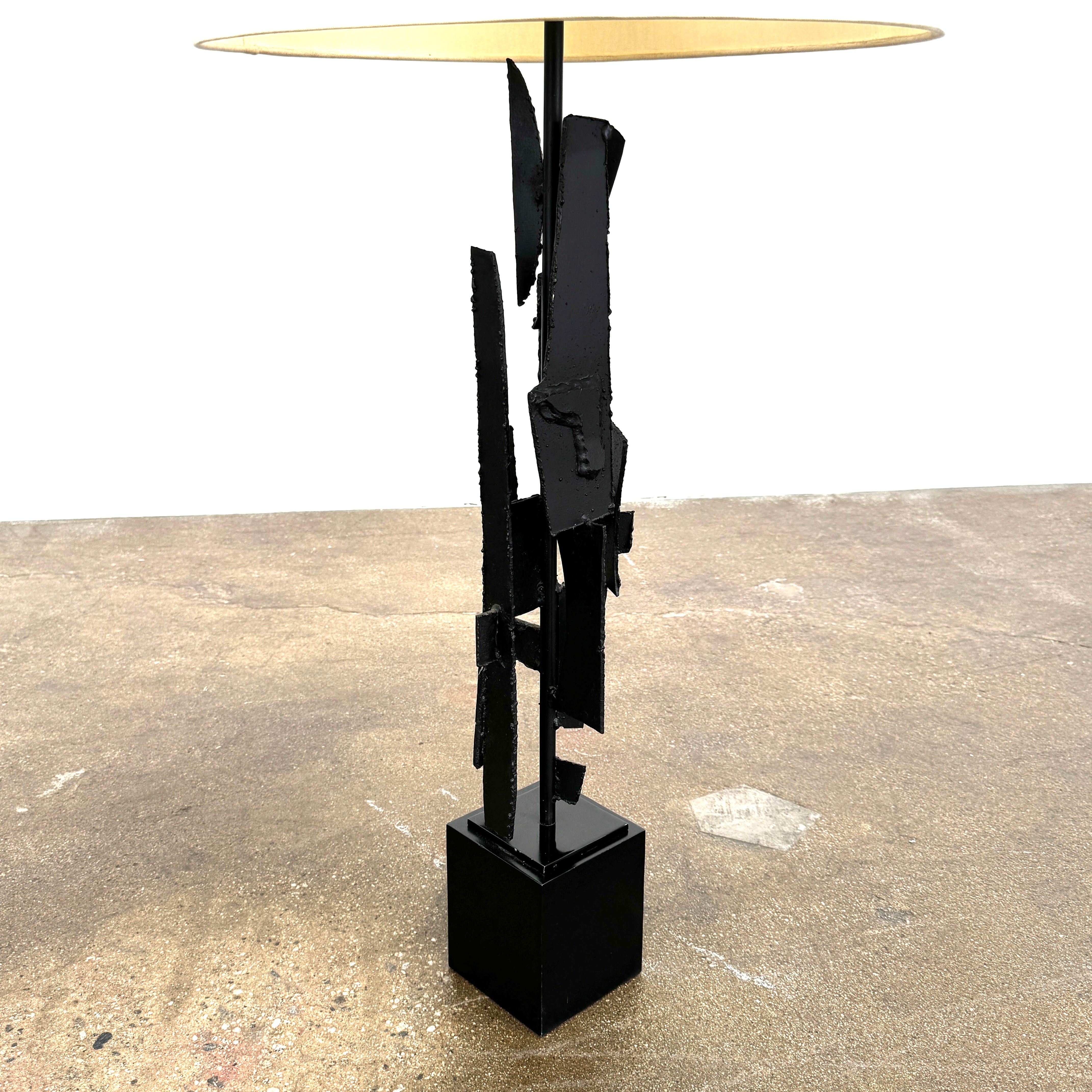 A pair of Vintage Richard Barr Iron Brutalist table lamps for Laurel Lamp Co., featuring abstract black metal bases and cylindrical white shades, set against a plain white background.