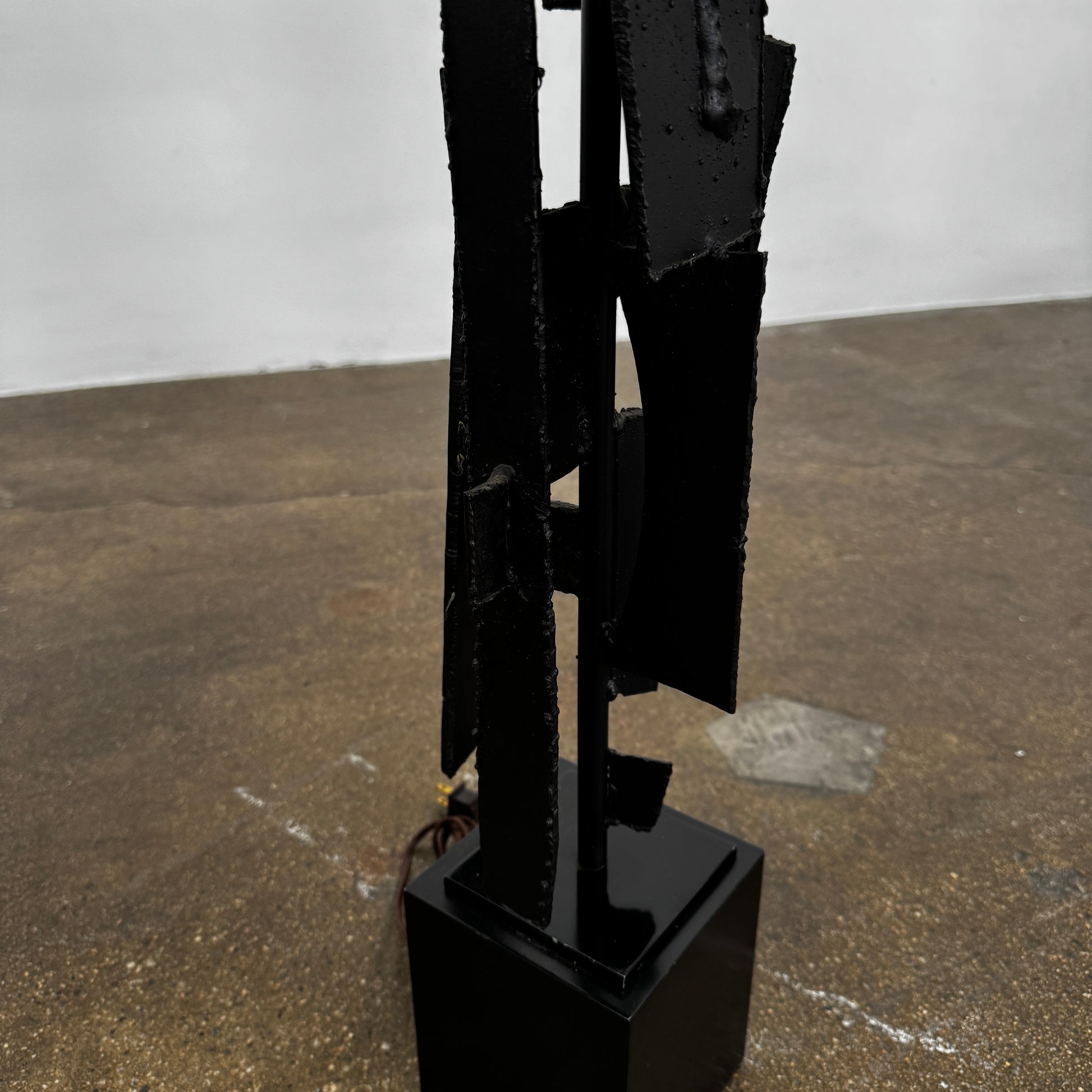 A pair of Vintage Richard Barr Iron Brutalist table lamps for Laurel Lamp Co., featuring abstract black metal bases and cylindrical white shades, set against a plain white background.