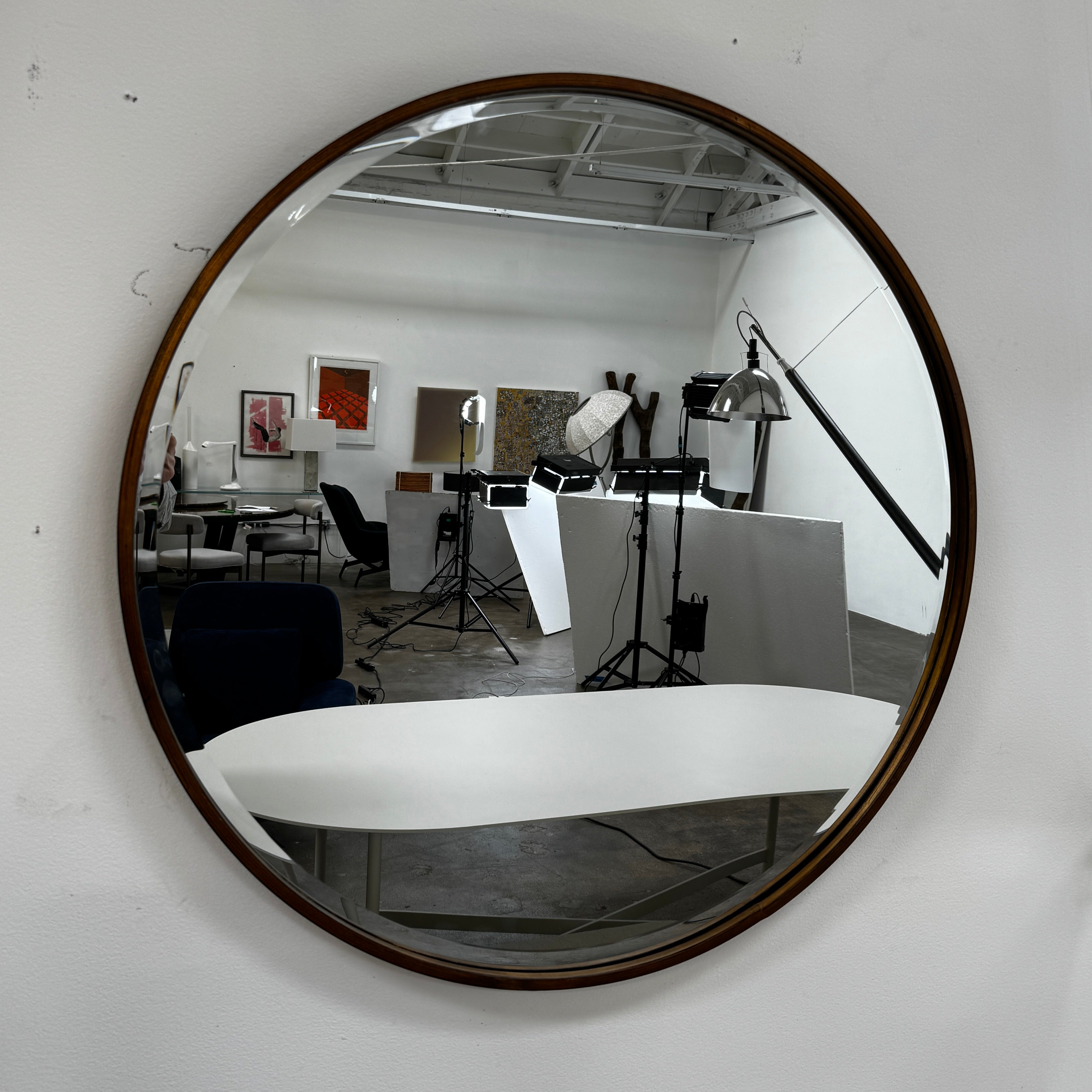 The Uttermost Round Mirror by Uttermost features a bronzed patina and hangs elegantly on the wall.