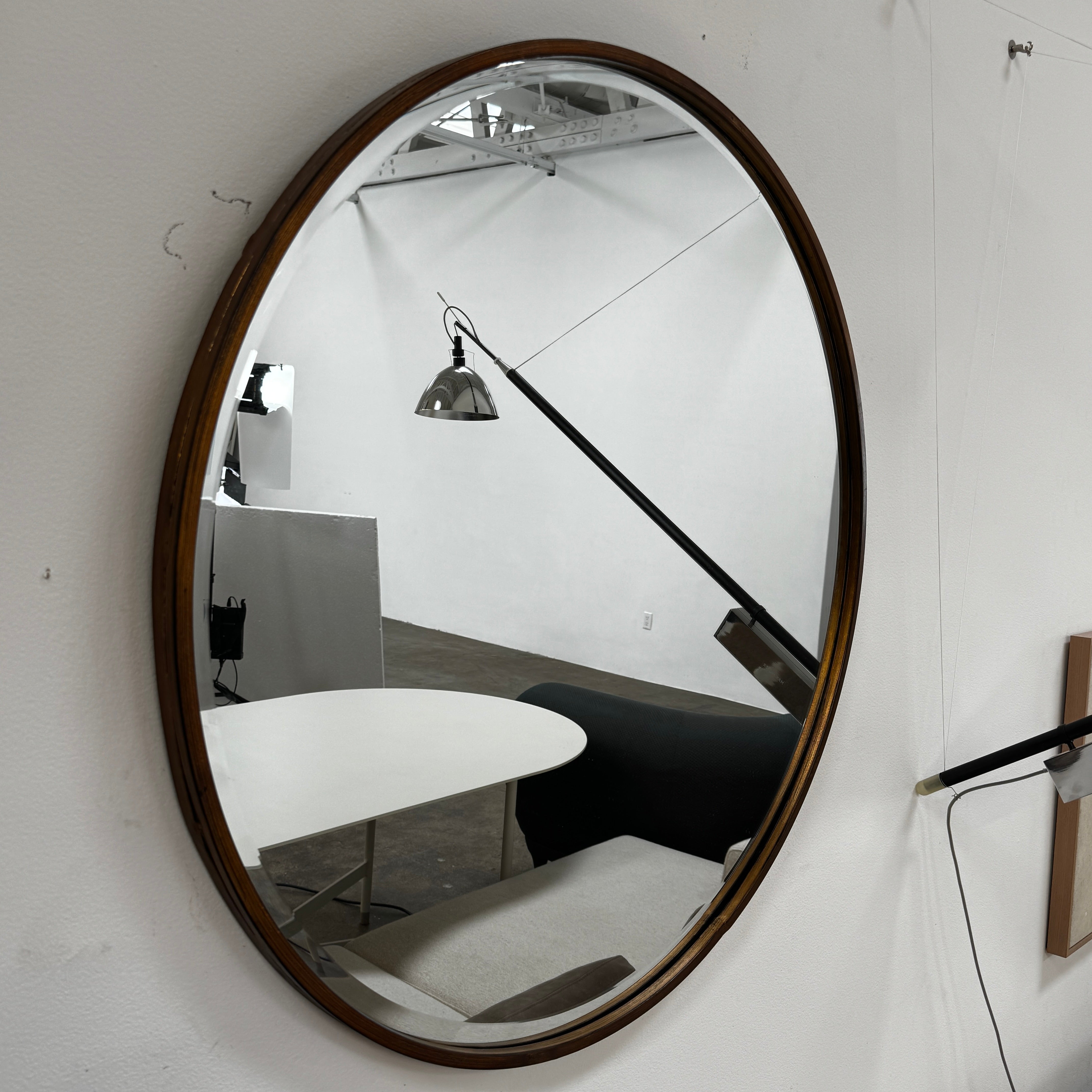 The Uttermost Round Mirror by Uttermost features a bronzed patina and hangs elegantly on the wall.