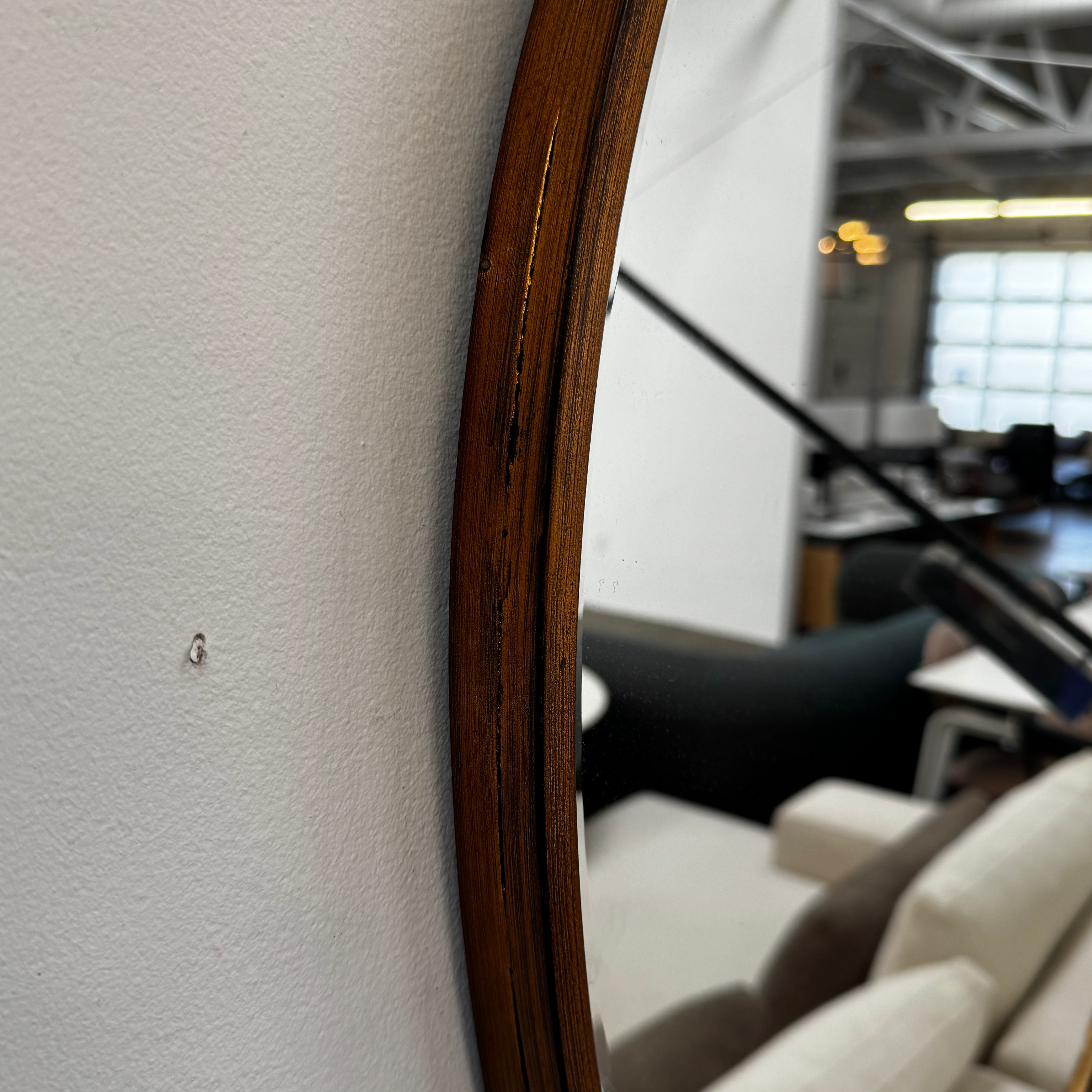 The Uttermost Round Mirror by Uttermost features a bronzed patina and hangs elegantly on the wall.