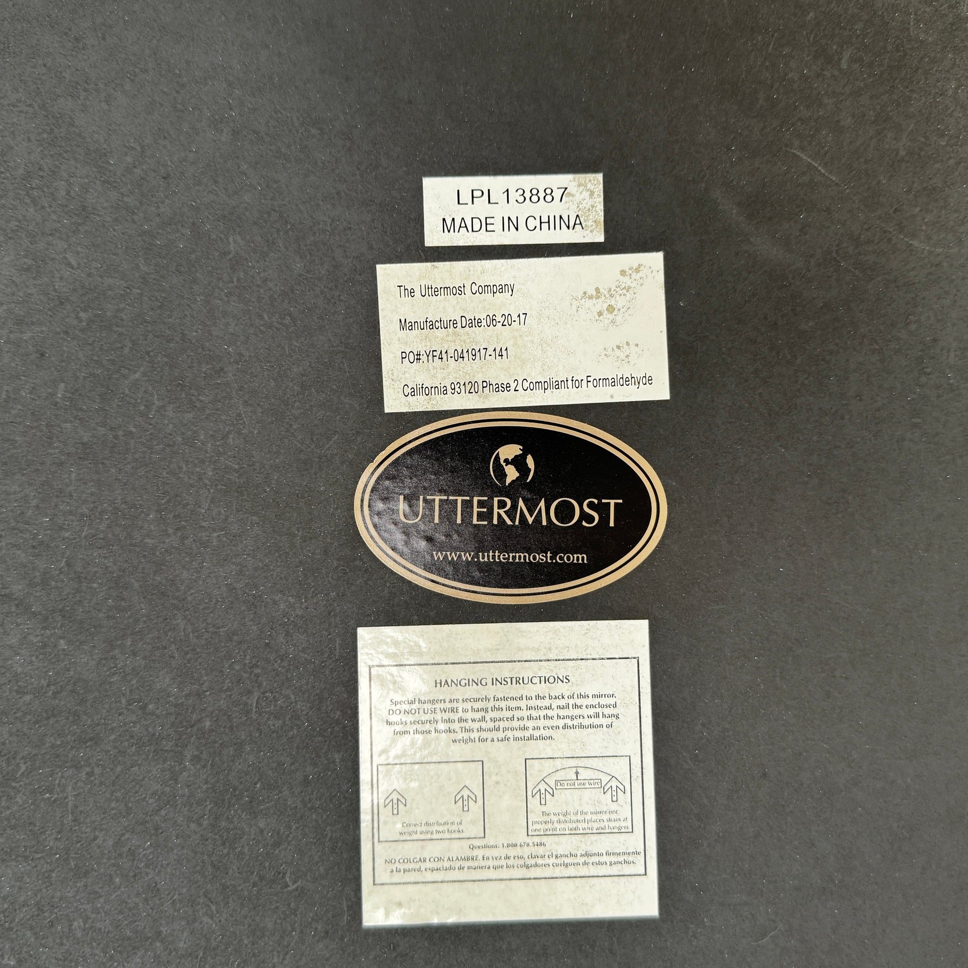 The Uttermost Round Mirror by Uttermost features a bronzed patina and hangs elegantly on the wall.