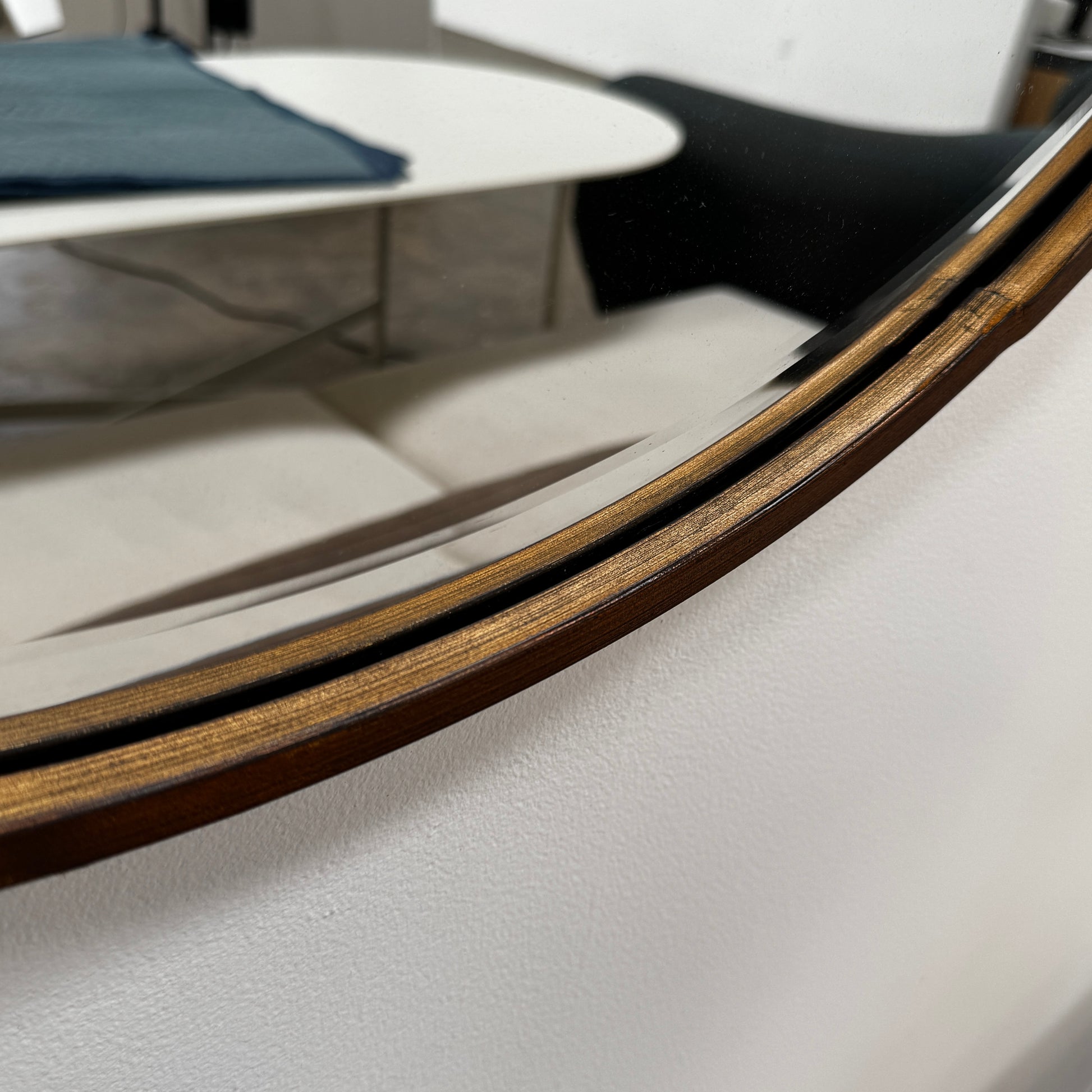 The Uttermost Round Mirror by Uttermost features a bronzed patina and hangs elegantly on the wall.