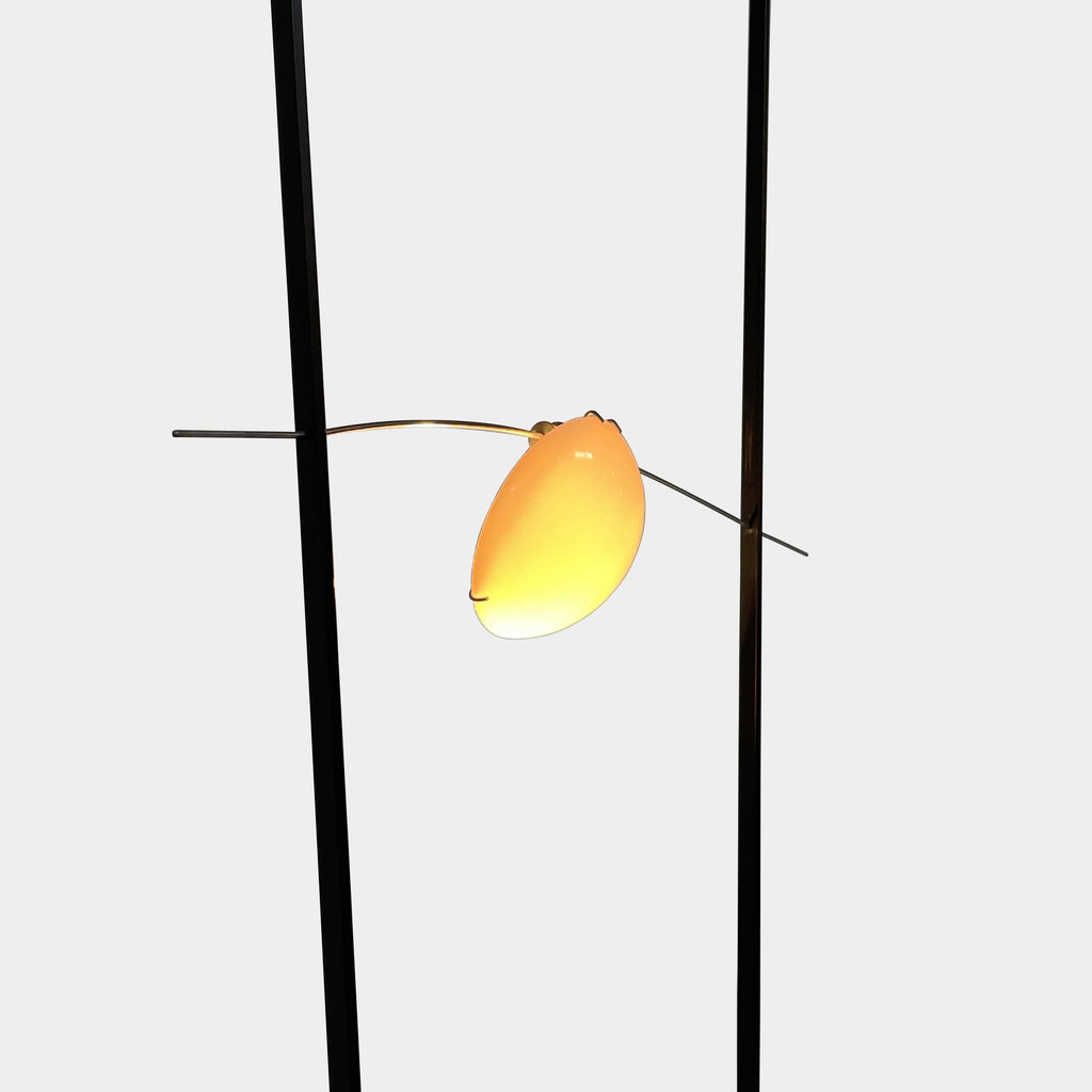 An Ingo Maurer Ilios Floor Light with two metal poles and a yellow bulb.