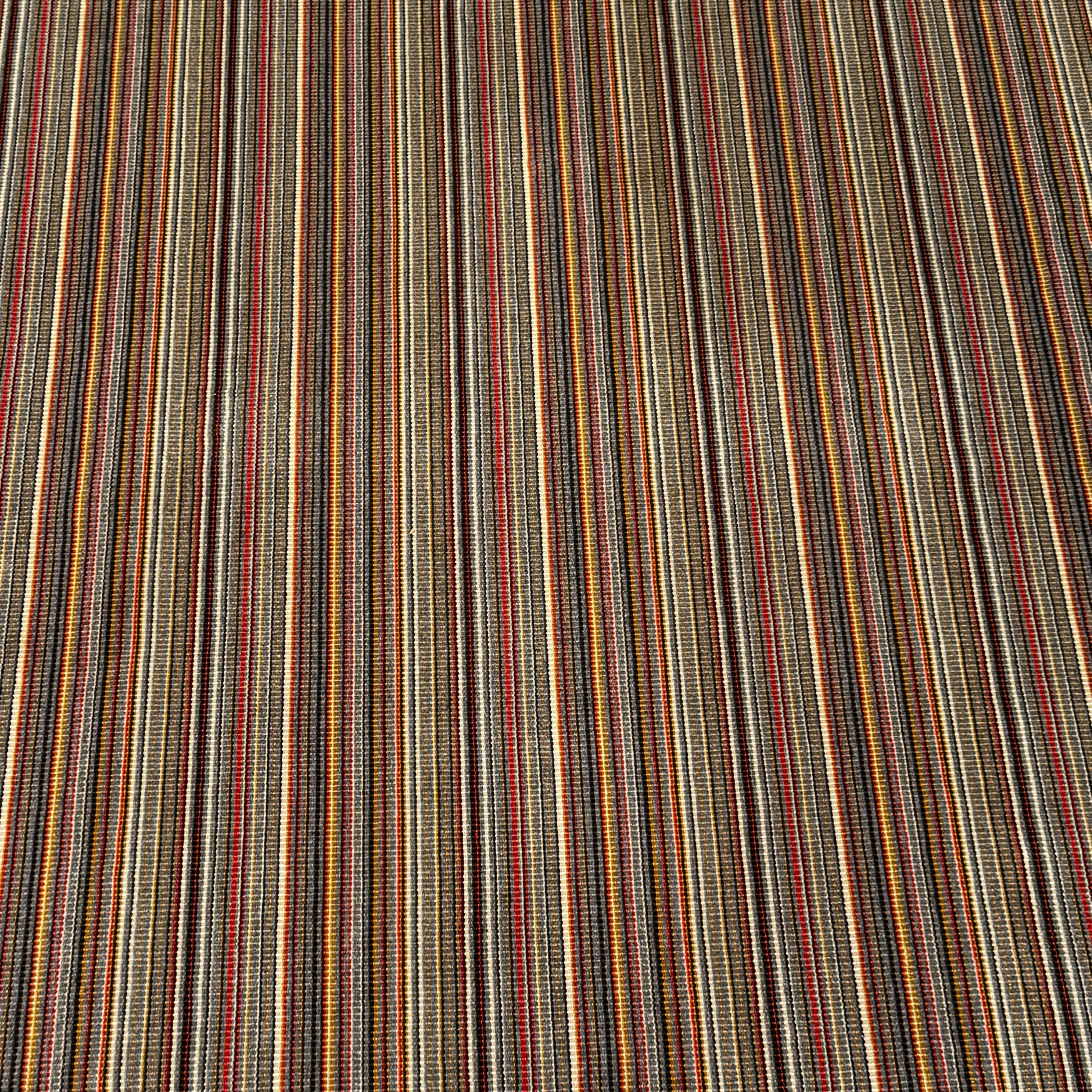 A close-up of the Maharam Interval Area Rug by Herman Miller, a modern New Zealand wool rug featuring gray, red, yellow, white, and brown stripes, shown on a white background.