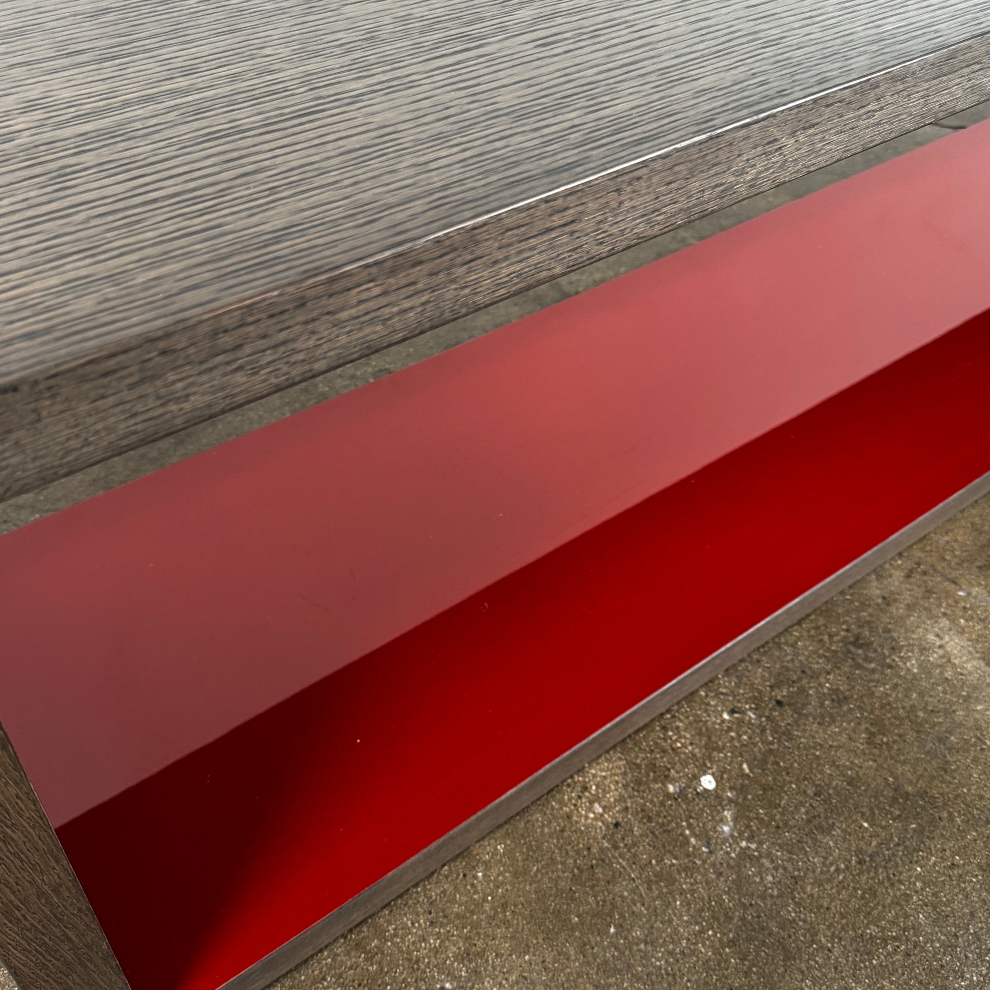 The B&B Italia Frank Low Console Table by B&B Italia features a rectangular, low-profile design with an open base and red interior shelf, shown against a plain white background.