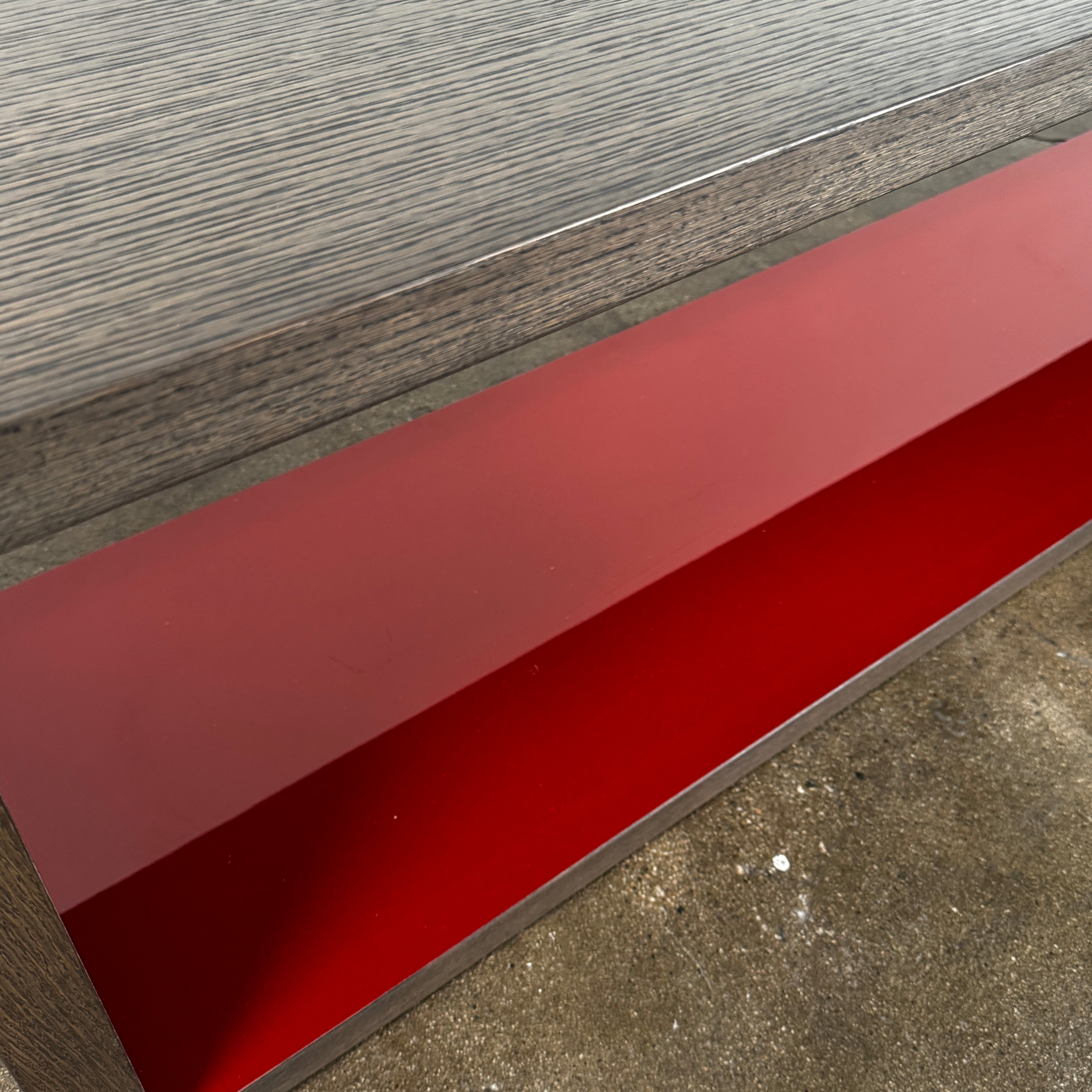 The B&B Italia Frank Low Console Table by B&B Italia features a rectangular, low-profile design with an open base and red interior shelf, shown against a plain white background.