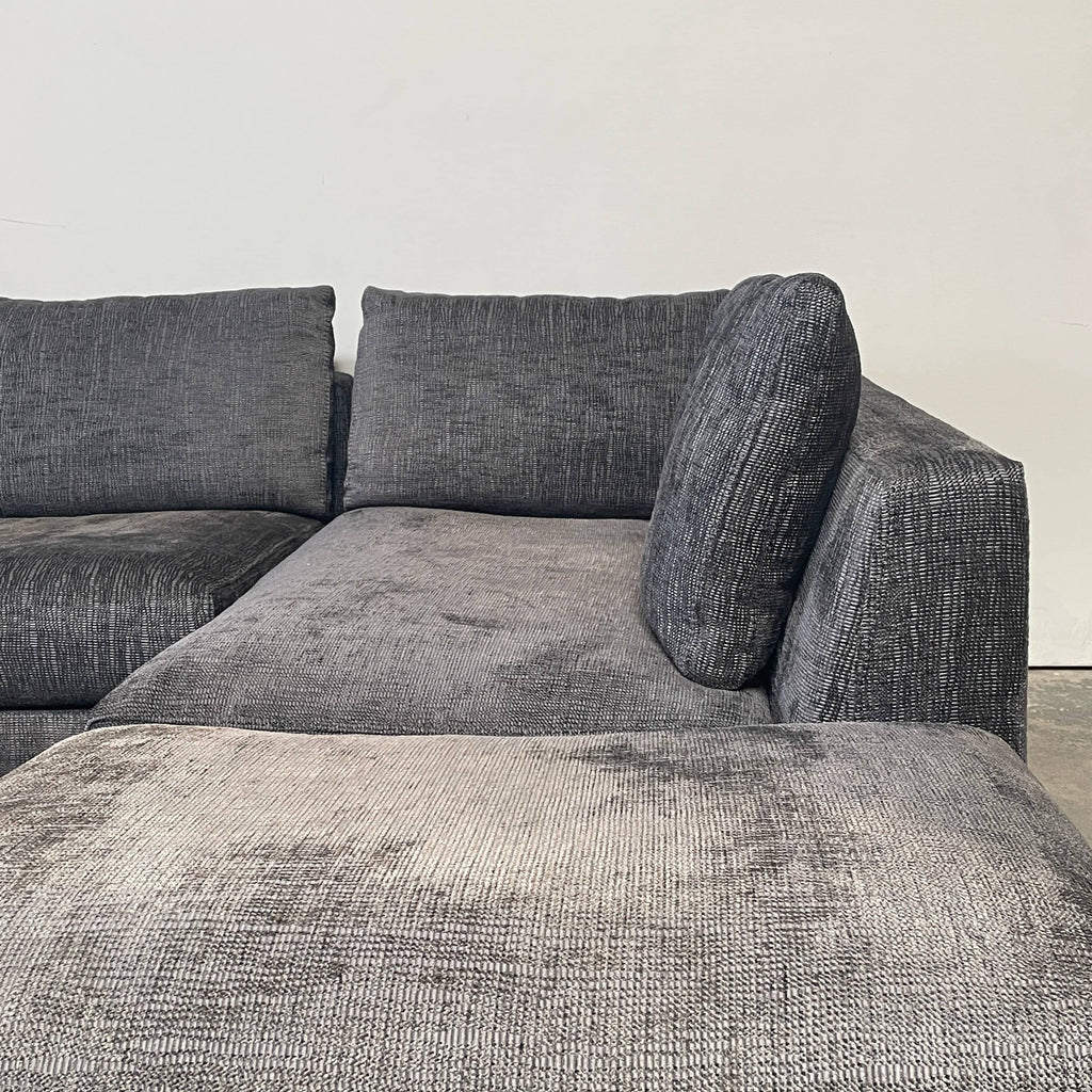 B&B Italia Ray Sectional Sofa with deep blue-gray textured fabric and additional loose cushions, isolated on a white background.