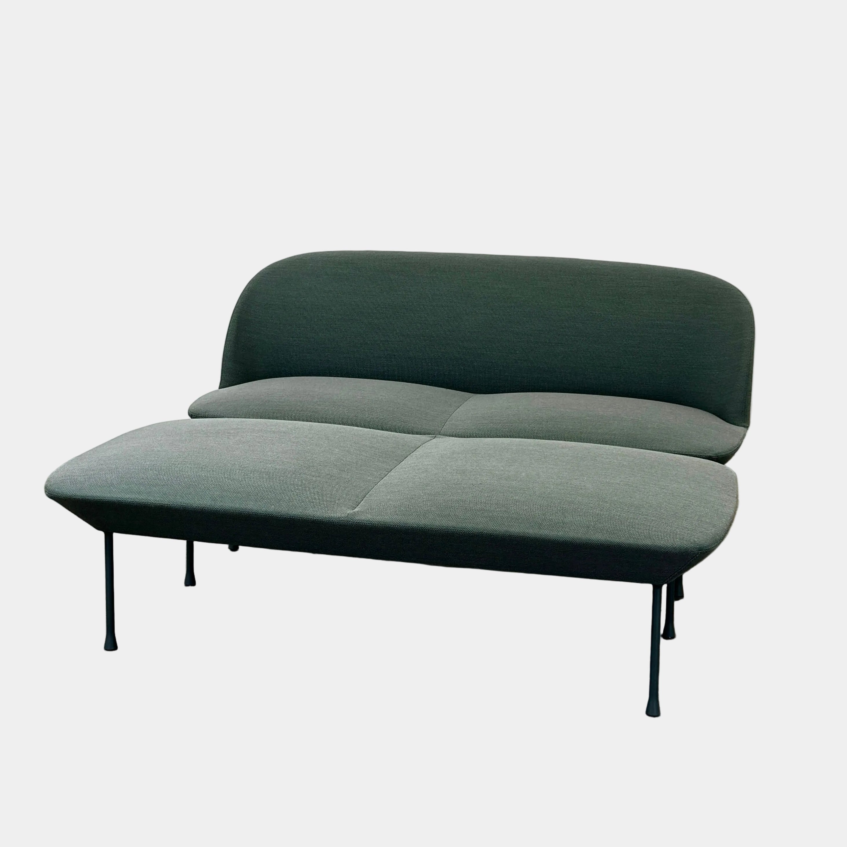 The Muuto Oslo 2-seat sofa & bench by Modern Resale features dark green upholstery and slim black metal legs, showcasing a modern Danish-inspired minimalist design against a plain white background.