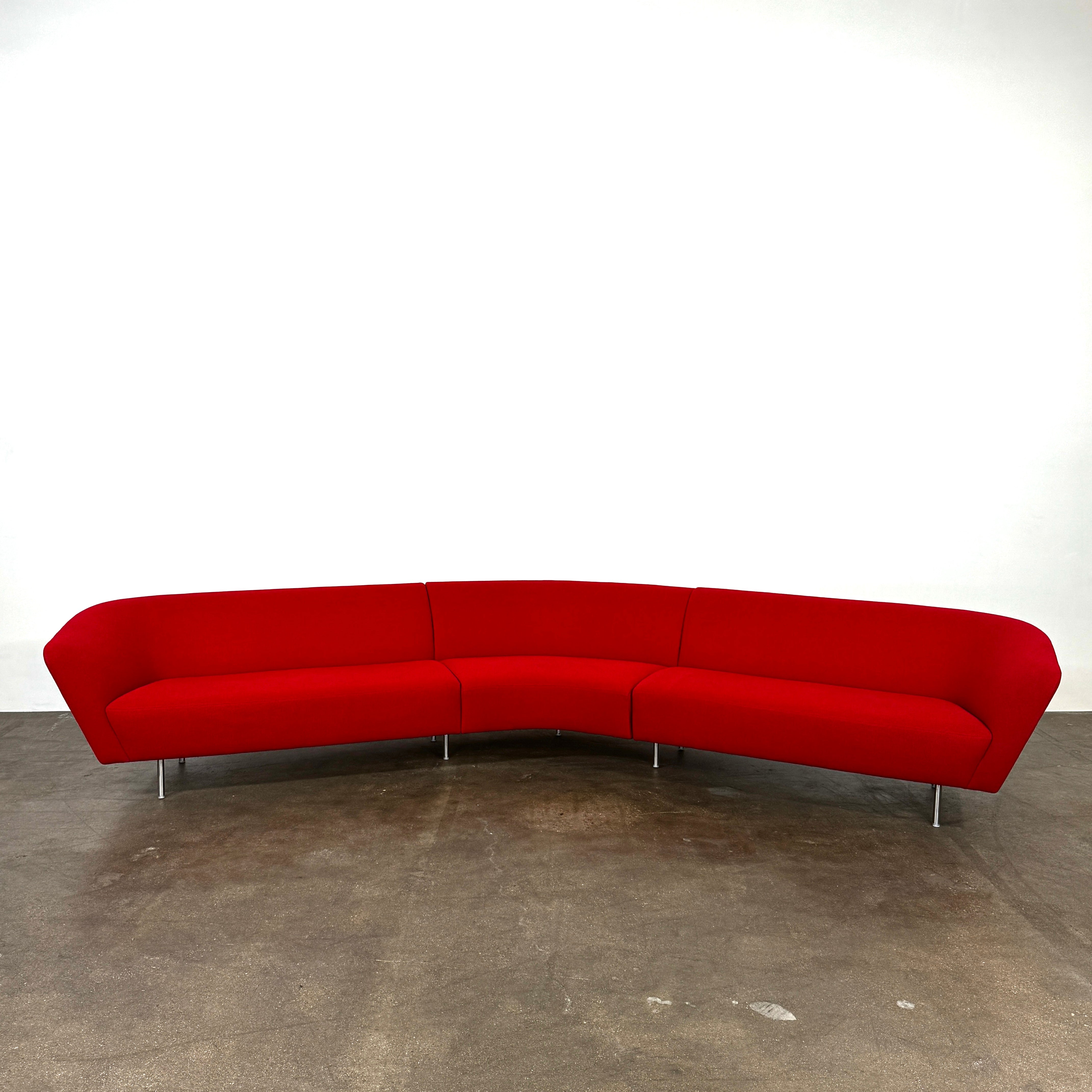 The Arper Loop Modular Sofa by Arper features a modern curved design with a geometric profile and metal legs, shown at an angle against a plain white background.