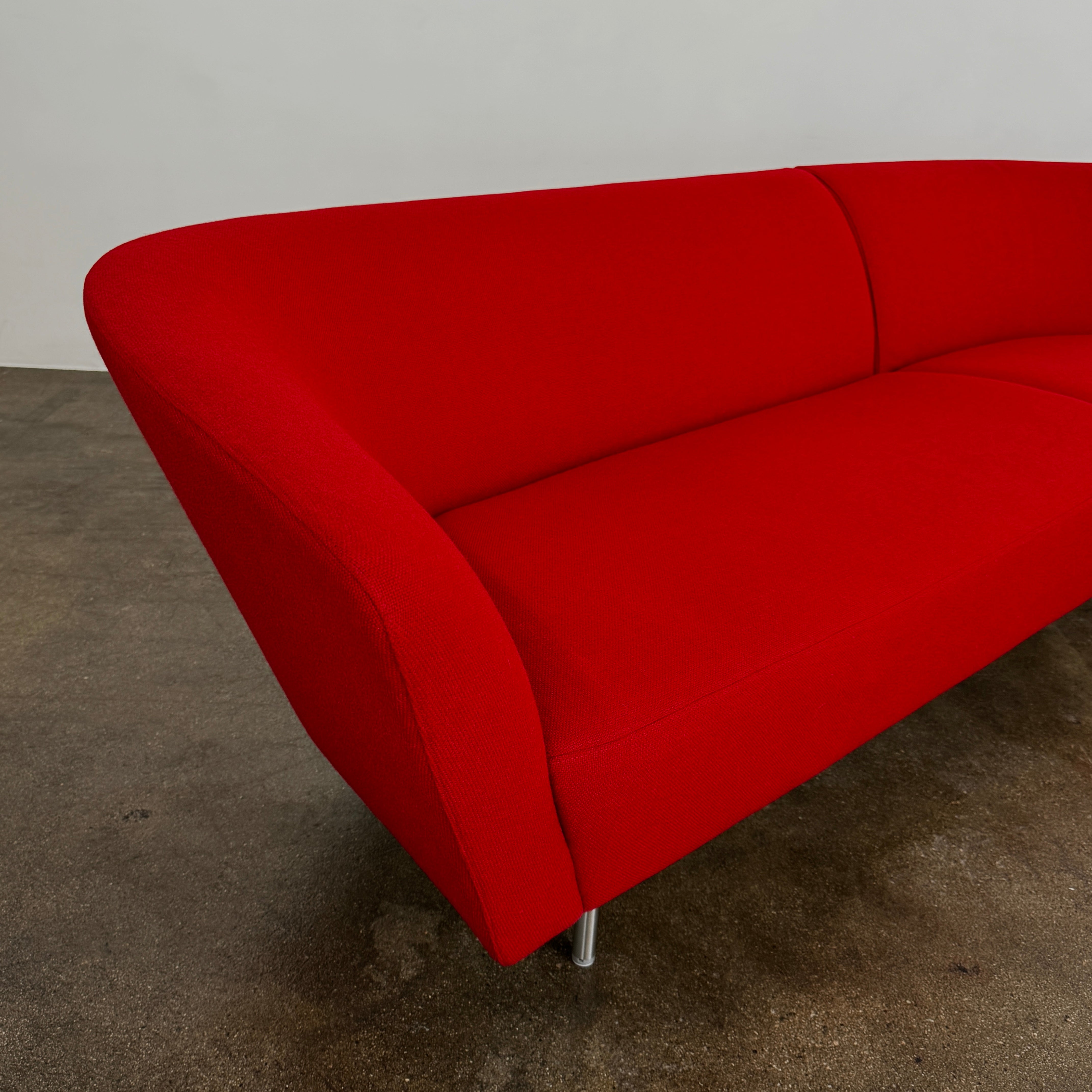The Arper Loop Modular Sofa by Arper features a modern curved design with a geometric profile and metal legs, shown at an angle against a plain white background.