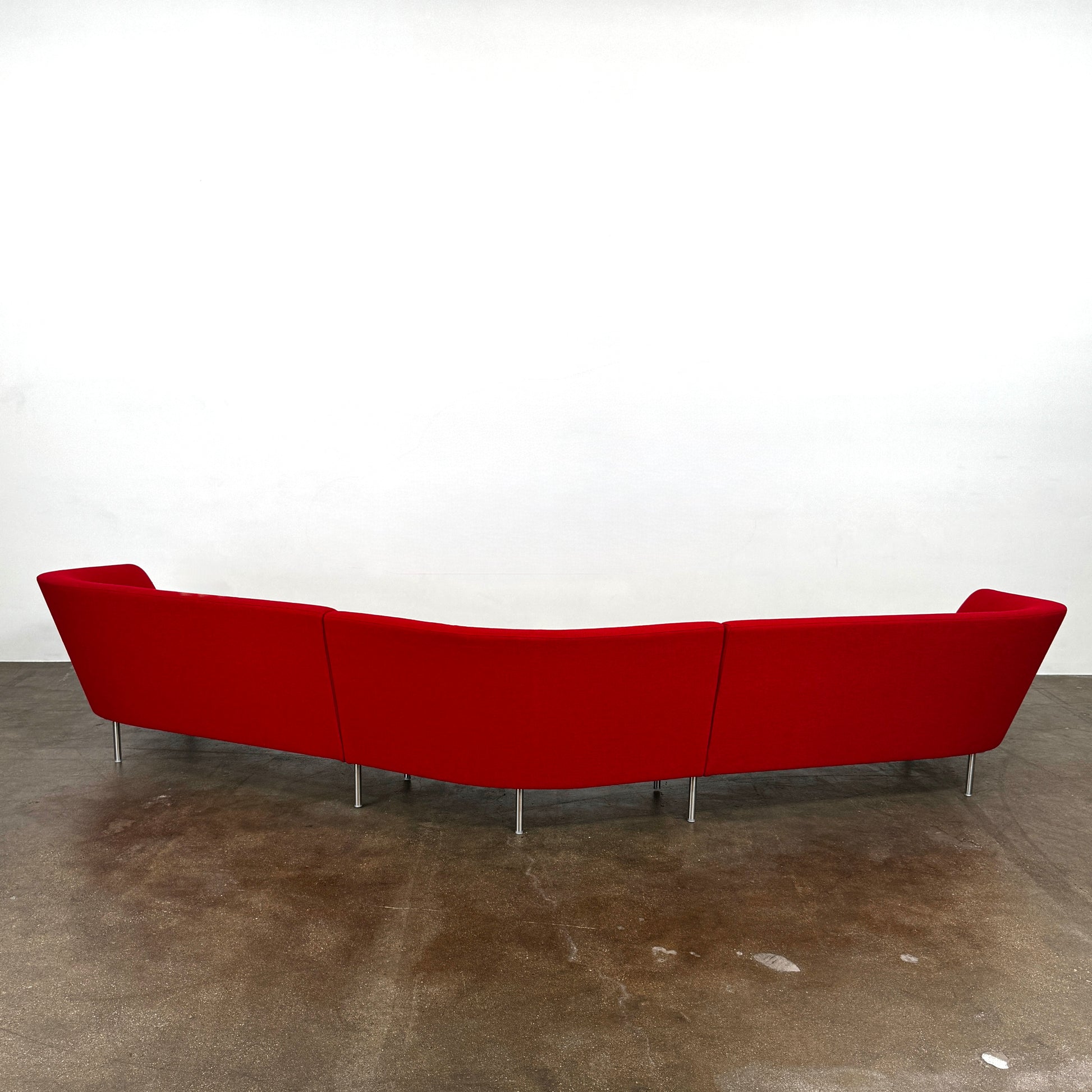 The Arper Loop Modular Sofa by Arper features a modern curved design with a geometric profile and metal legs, shown at an angle against a plain white background.