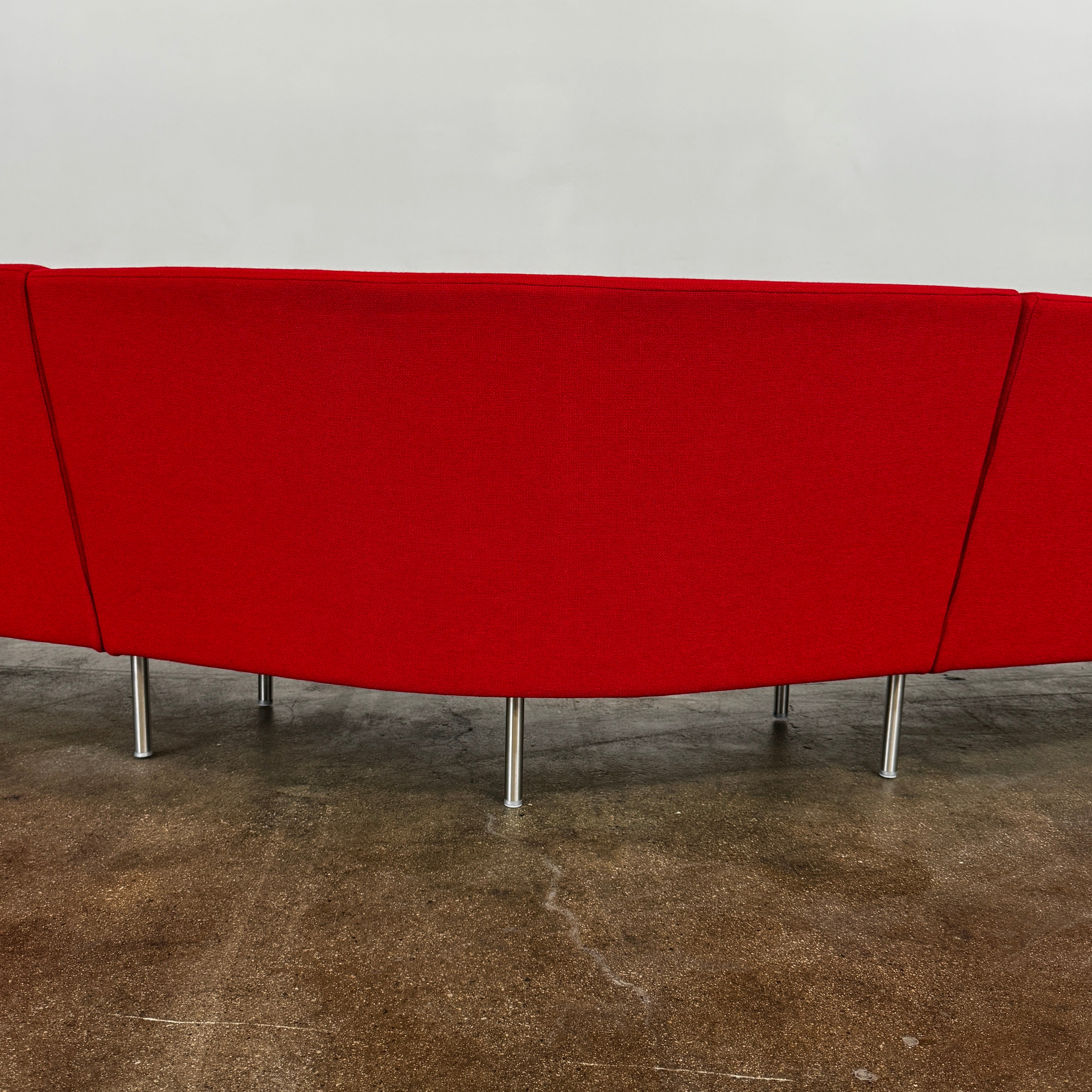 The Arper Loop Modular Sofa by Arper features a modern curved design with a geometric profile and metal legs, shown at an angle against a plain white background.