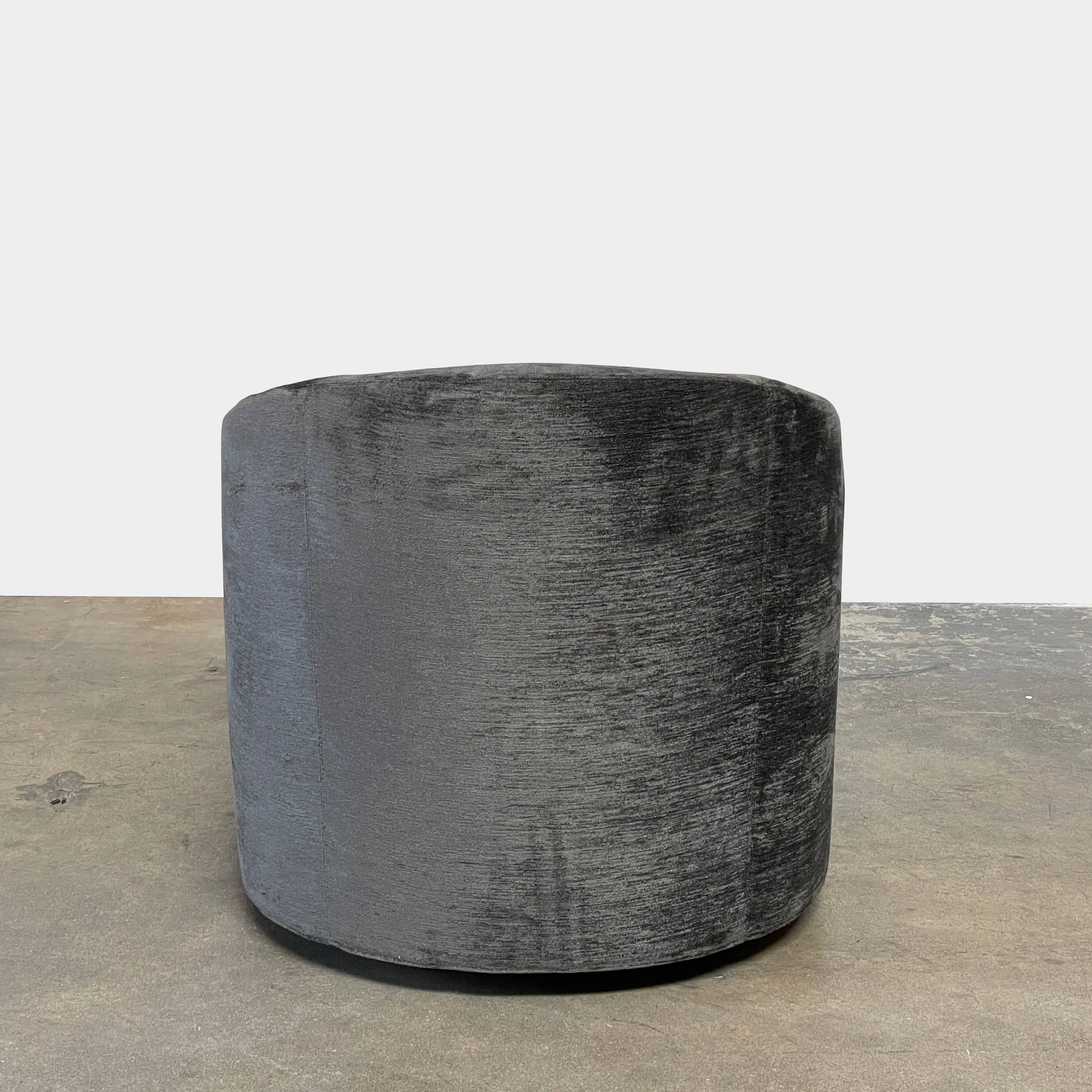 The Minotti Quinn Swivel Lounge Chair Set of 2 showcases a minimalist design with dark gray, curved forms in luxurious chenille. Ideal for the living room, these modern chairs stand out against a light gray backdrop.