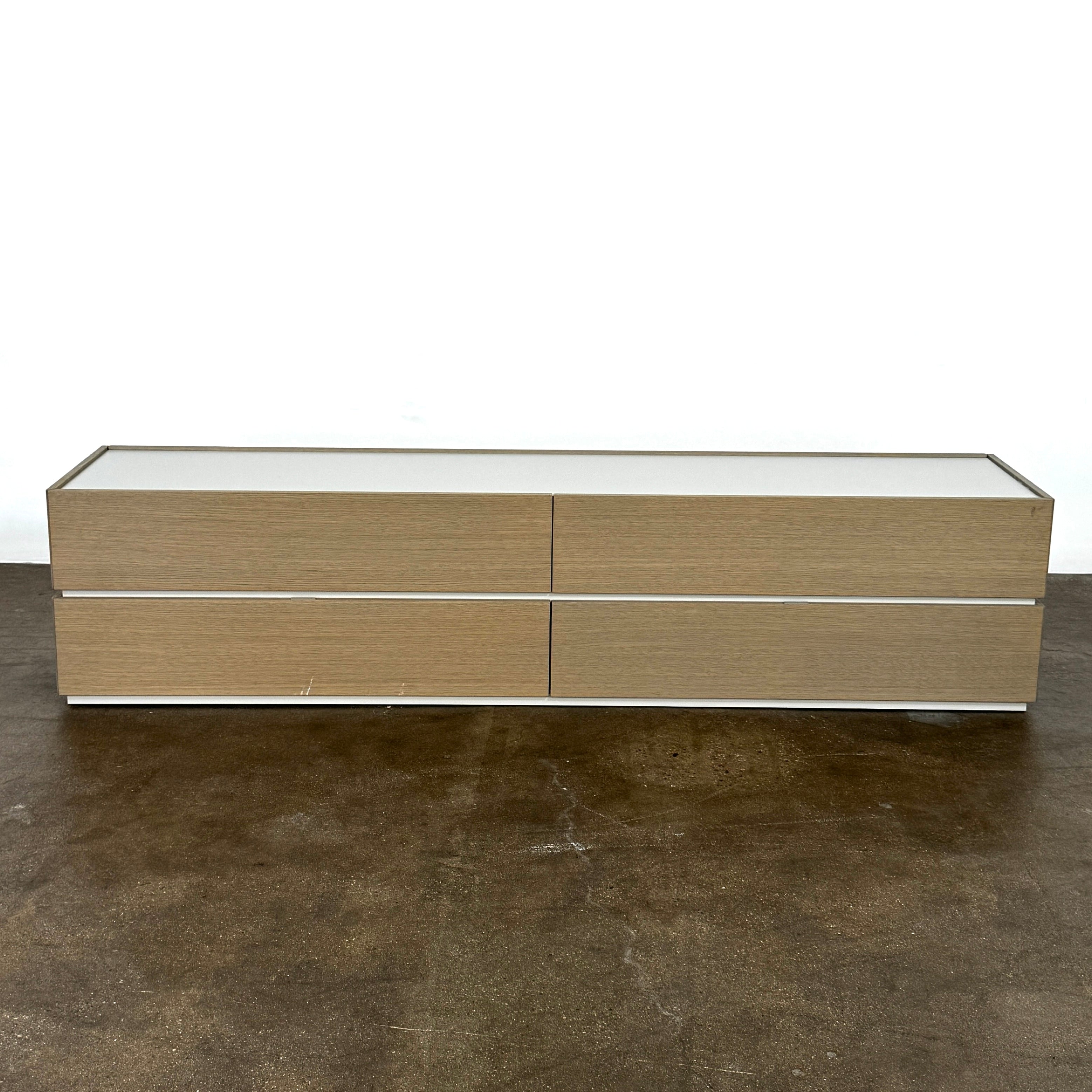 A rectangular wooden coffin with a simple, modern design and light wood finish, featuring clean lines inspired by the Sangiacomo Cidori Chest of Drawers by Sangiacomo, shown from the front against a white background.