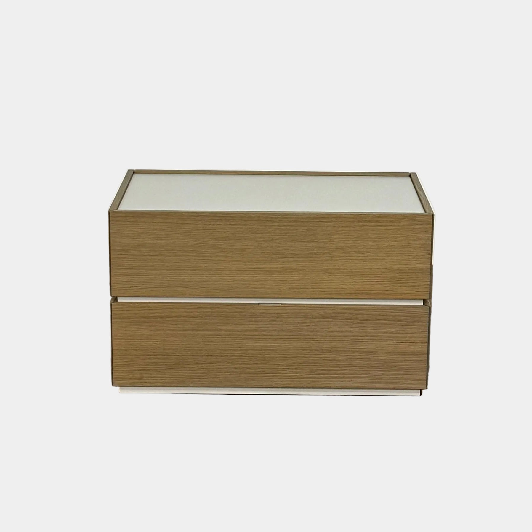 The Sangiacomo Cidori Small Chest of Drawers by Sangiacomo is ideal for contemporary spaces, featuring a light-toned top and single partially open drawer, set on a concrete floor against a white wall.