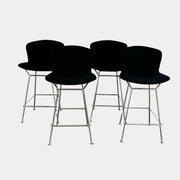 Close-up of a Knoll Bertoia Counter Stool from a set of 4, featuring a black cushion and textured black fabric over the backrest, placed on a polished concrete floor.