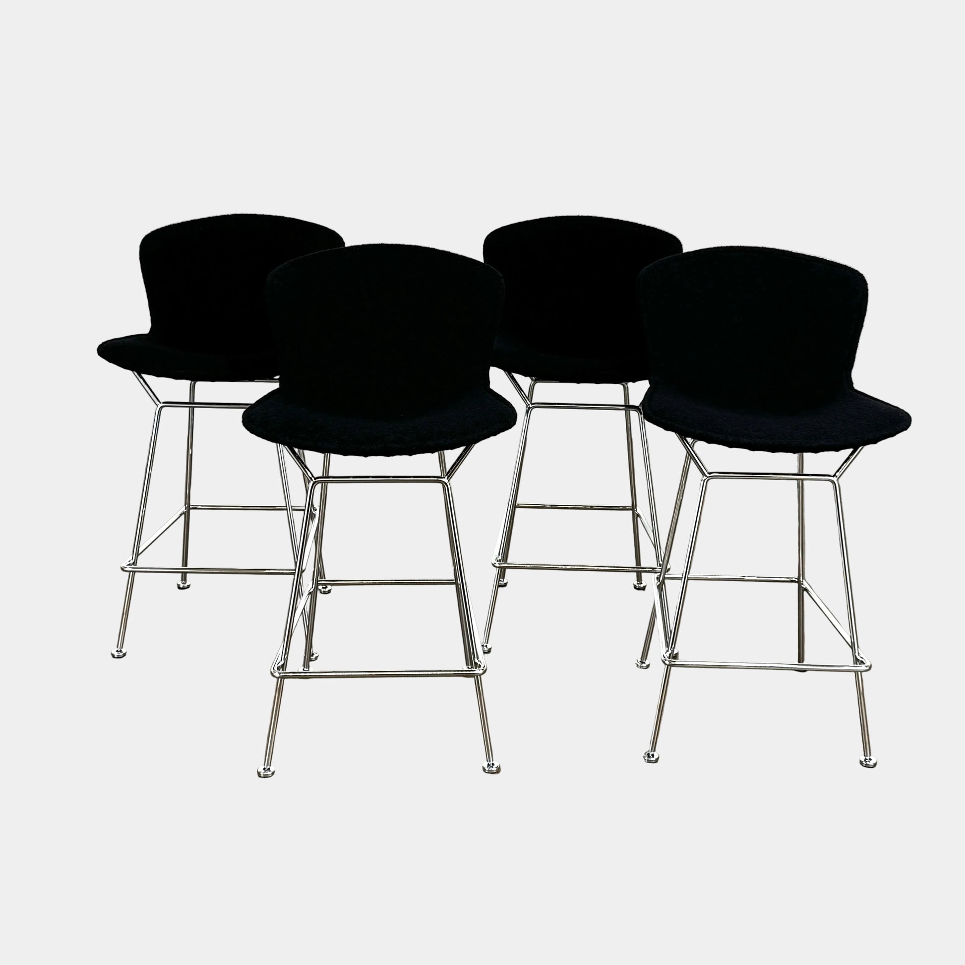 Close-up of a Knoll Bertoia Counter Stool from a set of 4, featuring a black cushion and textured black fabric over the backrest, placed on a polished concrete floor.